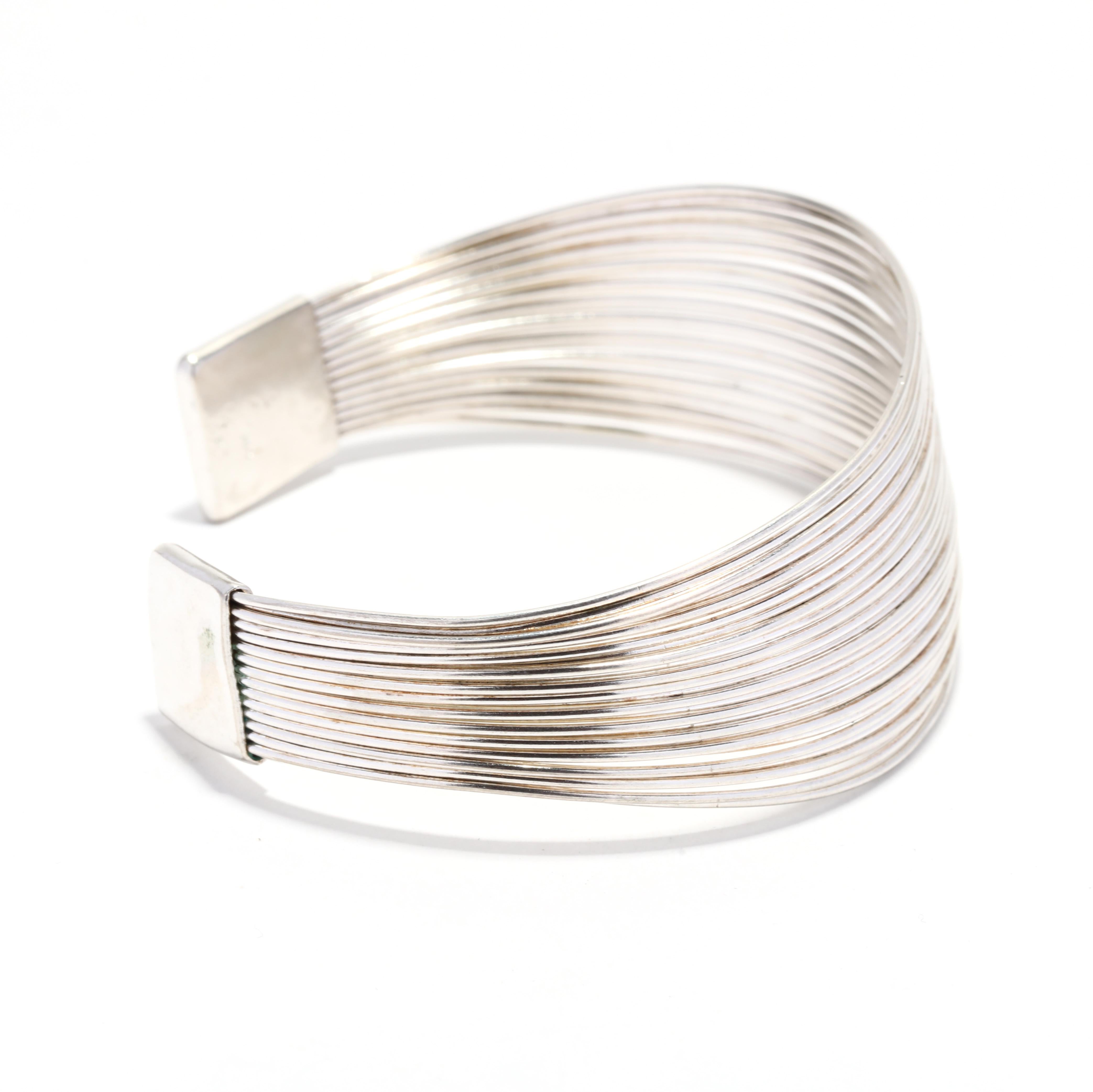 A vintage sterling silver multi-strand wire cuff bracelet.  This wide cuff bracelet features multiple strands of silver wire, joined at the terminals.  It is stamped 925.  

Length: 7 inch interior circumference with 1 1/8 inch opening

Width: 1