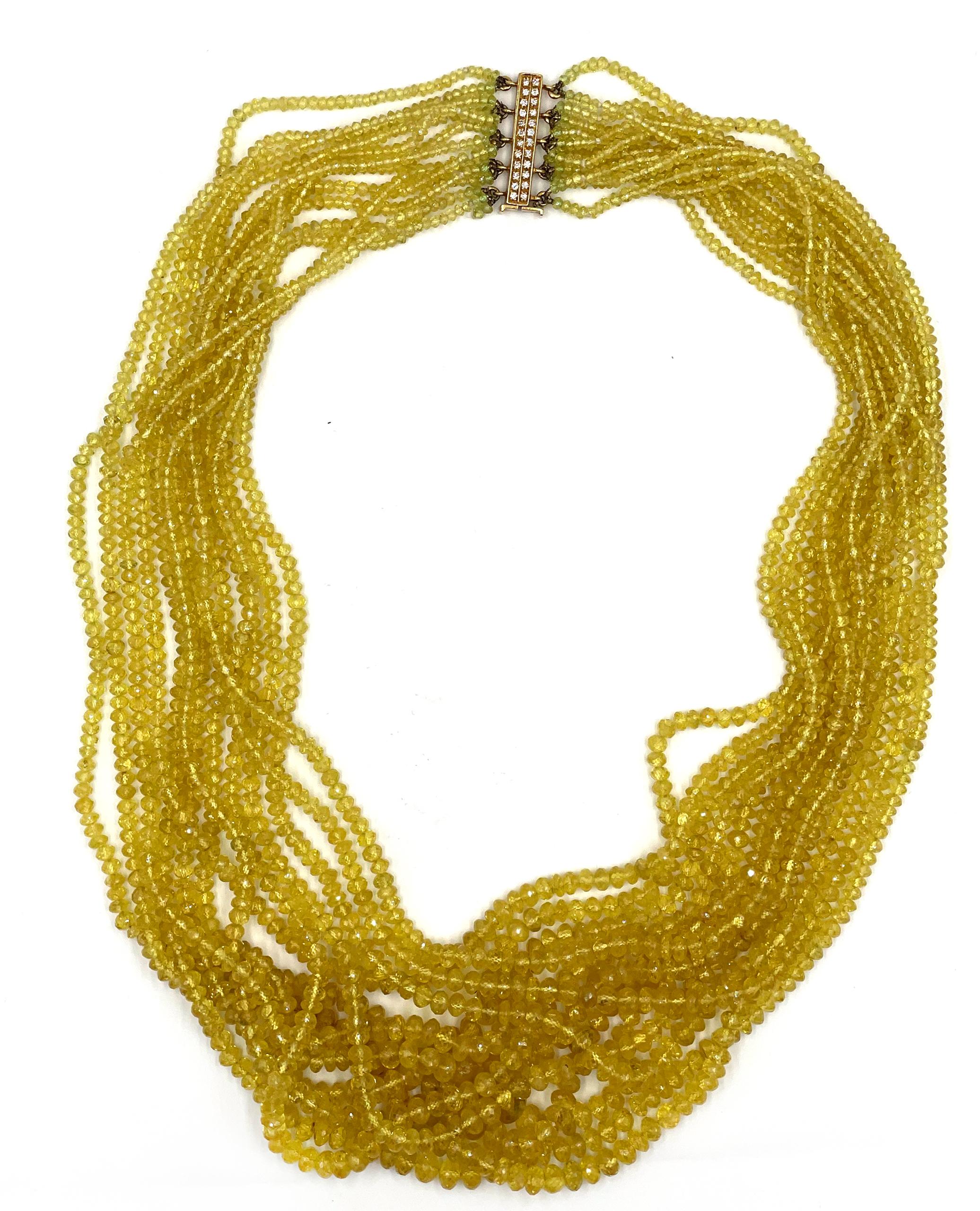 Pre owned vintage estate multi strand golden sapphire necklace with an 18K yellow gold and diamond clasp.  The necklace has 14 strands of faceted yellow sapphire beads and graduate in length from 20 inches to 25 inches long.  The yellow sapphires