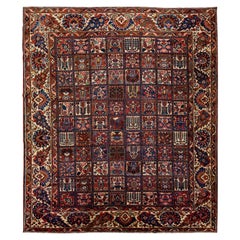 Tapis en laine multicolore, anciennement persan, de type Bakhtiari, fait à la main et à motifs multiples.