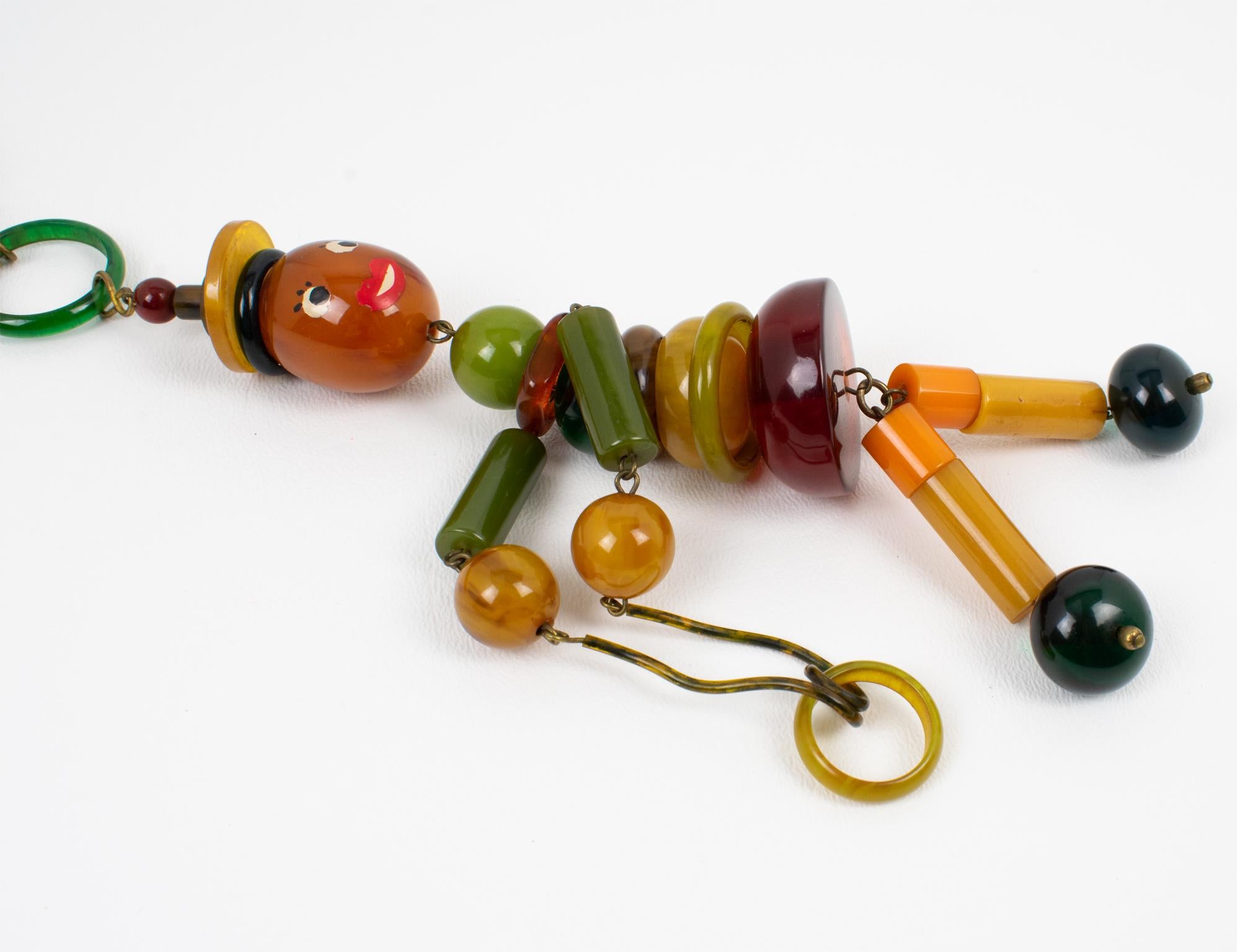 Multicolor Bakelite Long Necklace with Articulated Crib Toy Doll Pendant, 1940s For Sale 1