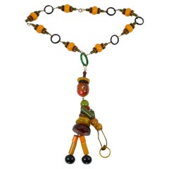 Retro Multicolor Bakelite Long Necklace with Articulated Crib Toy Doll Pendant, 1940s