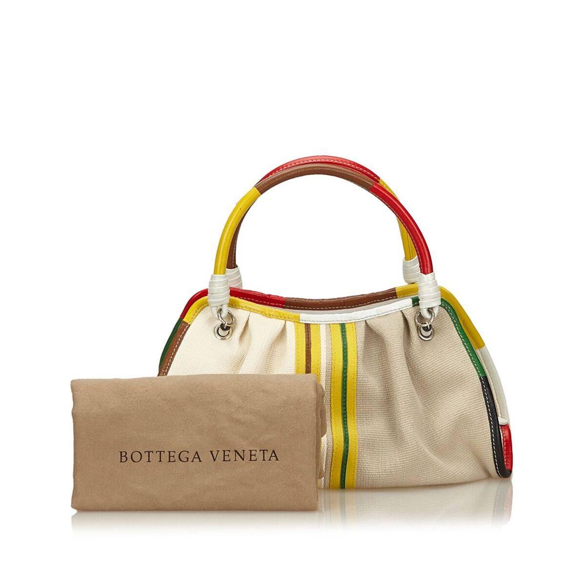 Product details:  Tan canvas tote bag by Bottega Veneta.  Trimmed with multicolor leather.  Dual carry handles.  Open top.  Lined interior with inner zip and open pockets.  Silvertone hardware.  Dust bag included.  13