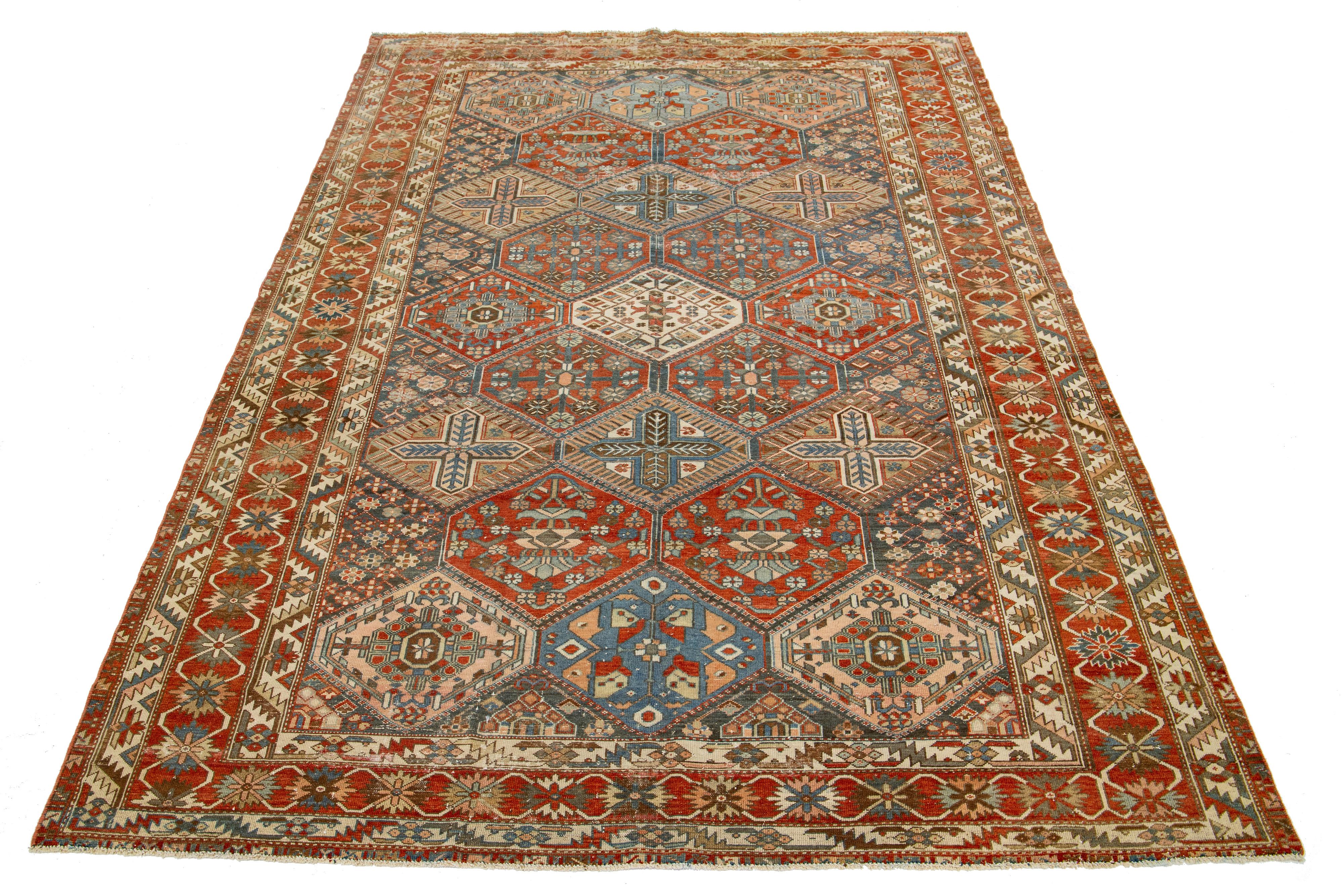 This beautiful Antique Bakhtiari hand-knotted wool rug features a gray-blue color field. It showcases a classic Persian design with blue, beige, and rust floral colors.

This rug measures 6'9