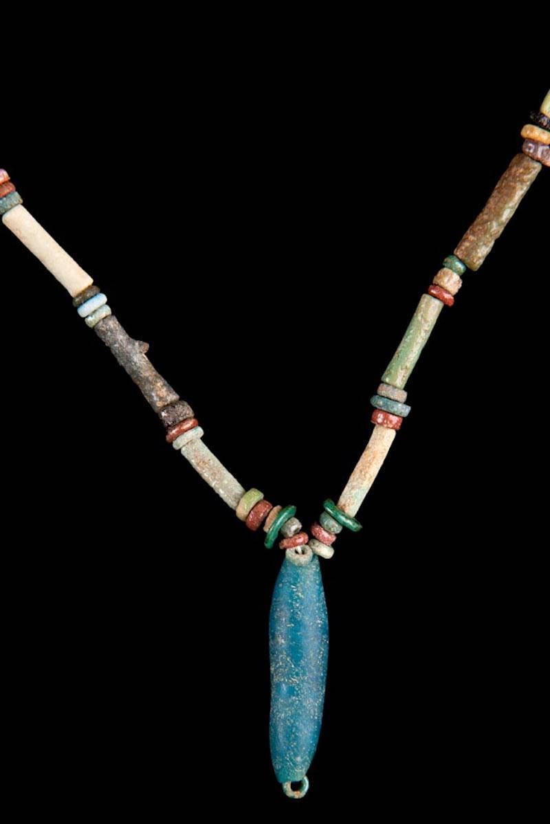Multicolor 2,500 years old faience beads adorn a beautiful blue amulet. Blue represented the Sky, Water, the Heavens, Primeval Flood, Creation and Rebirth. The color is also associated with birth and rebirth because the annual flood of the River