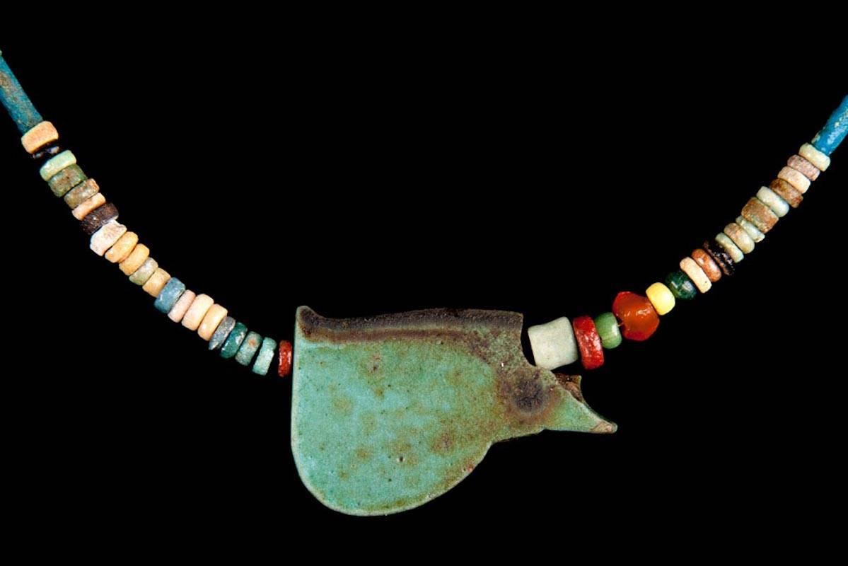 Ancient Egyptian multicolor faience bead necklace with olive green Eye of Ra amulet.