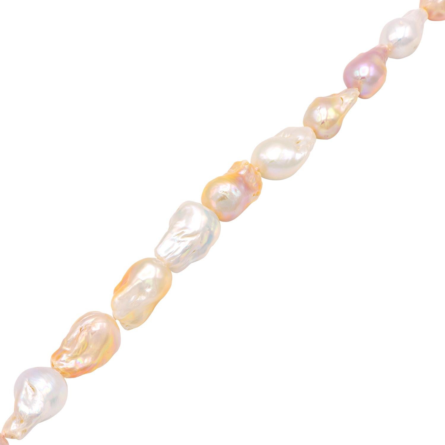 Ce magnifique rang de perles d'eau douce est composé de grandes perles baroques blanches, roses et pêche. Chaque perle a une forme et une couleur uniques, ce qui en fait un collier vraiment unique en son genre. Il s'agit de 15 perles brillantes de