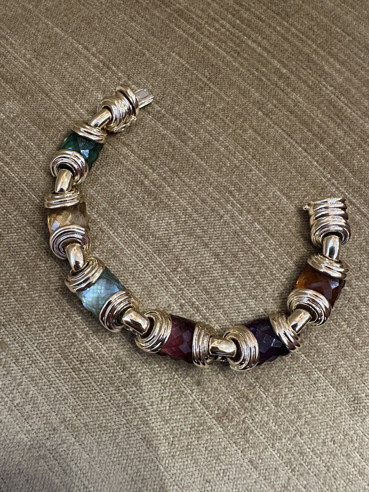 Bracelet de pierres multicolores en or jaune 18k

Le bracelet de pierres multicolores comprend six améthystes, topazes bleues, citrines et tourmalines vertes/roses de taille fantaisie aux couleurs vibrantes et profondes, serties dans de l'or jaune