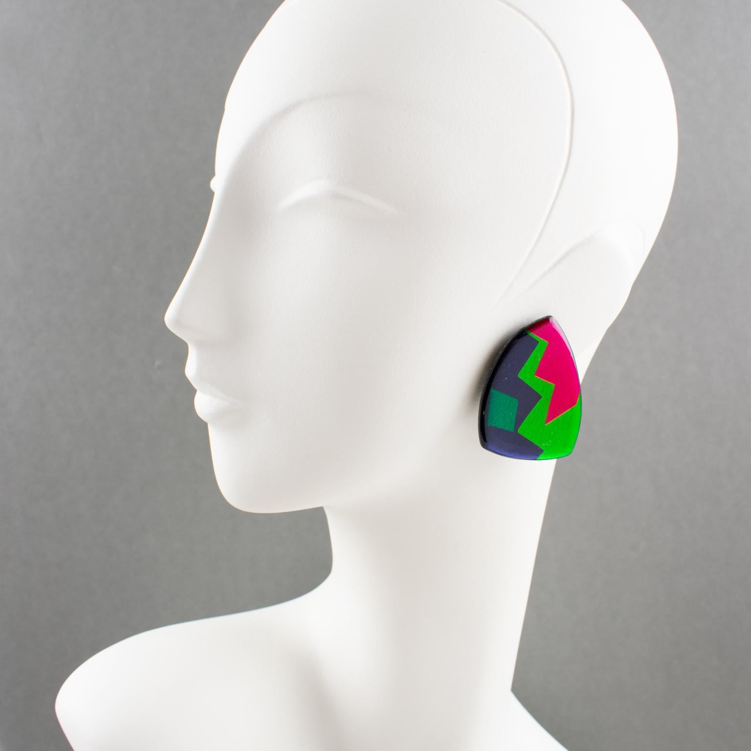 These lovely dangling Resin or Lucite clip-on earrings from an Italian designer studio, feature a geometric triangle design in emerald green, green grass, hot pink, and cobalt blue. They also have a mirror effect and a textured pattern, making them
