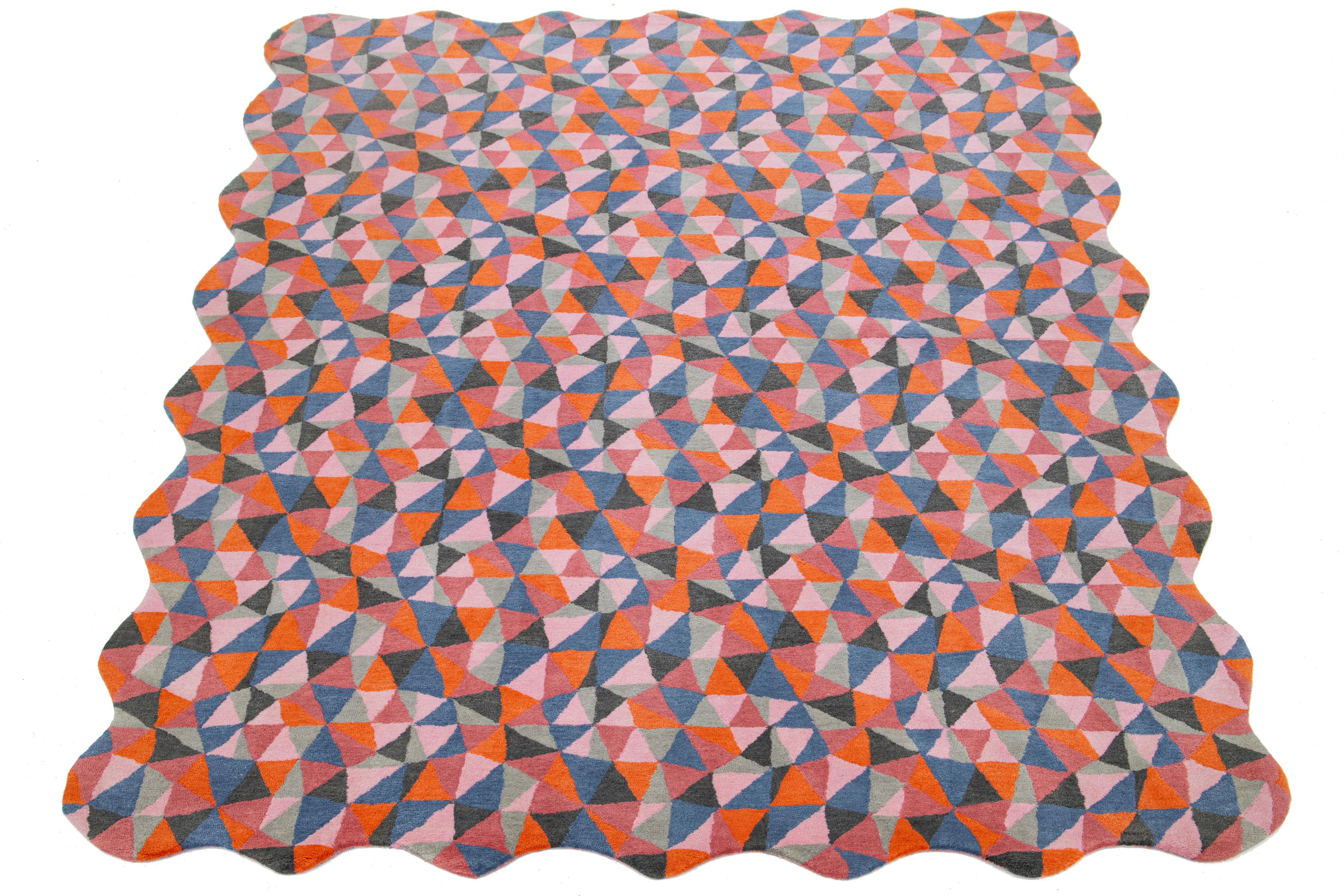 This beautiful, modern hand-tufted wool rug is part of our Laura Gottwald for Apadana Collection and features orange, blue, pink, and gray fields. This Mosaico design: A kaleidoscopic repeat pattern of free-hand triangles, Mosaico is reminiscent of