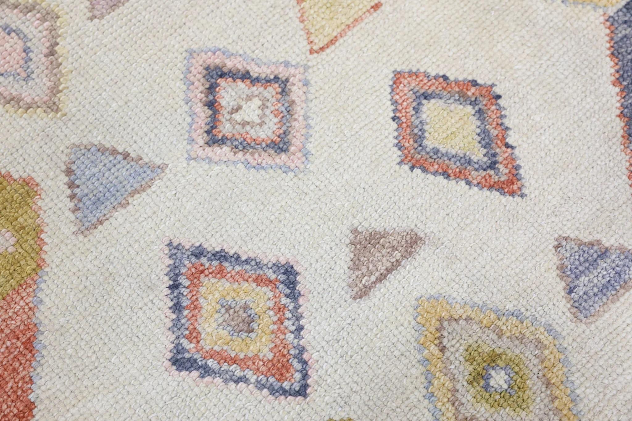 Entdecken Sie den lebendigen Charme dieses mehrfarbigen, handgewebten türkischen Oushak-Teppichs mit seinem auffälligen geometrischen Muster. Mit den Maßen 2'10
