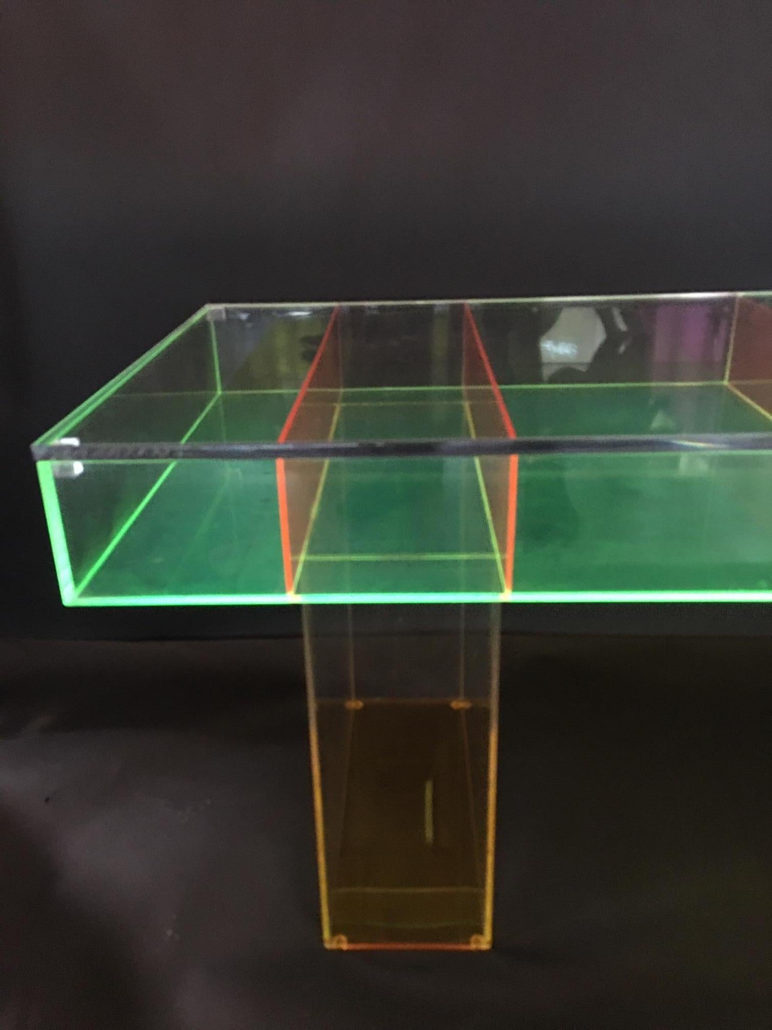 Custom multicolored Lucite coffee table. The tabletop base is lime green with bright orange legs and dividing pieces. The clear Lucite top of the table is removable, to place collectors items inside to present.
 