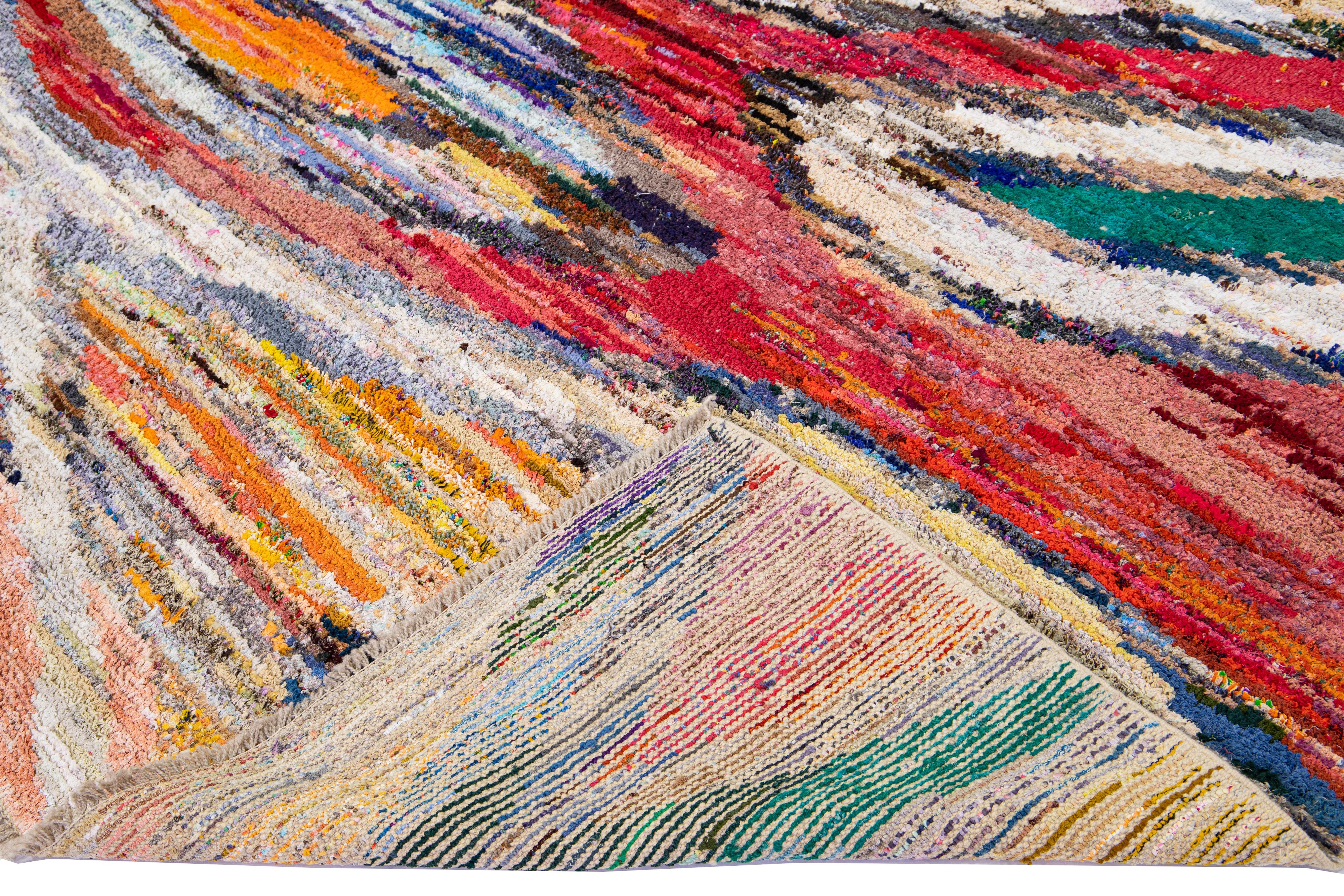 Wunderschöner türkischer handgefertigter Wollteppich mit einem mehrfarbigen Feld und Akzenten, die ein wunderschönes abstraktes Allover-Muster zeigen.

Dieser Teppich misst: 8'7'' x 11'7