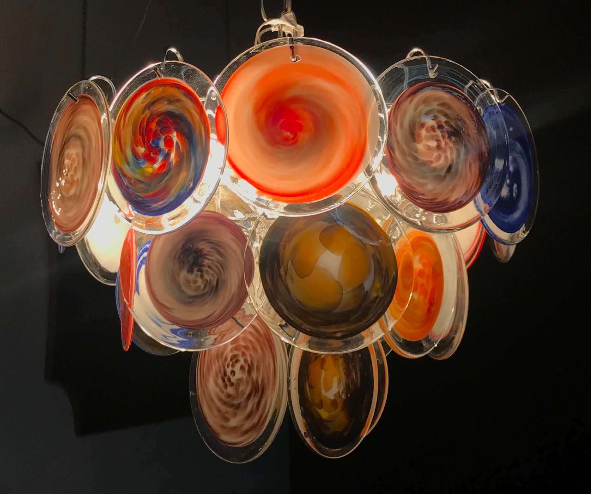 24 Multicolor discs of precious Murano glass are arranged on three levels. Each disc is a unique work of art .
Available also a Pair.

Nine E14 light bulbs.
Measures: Height without chain 40 cm.