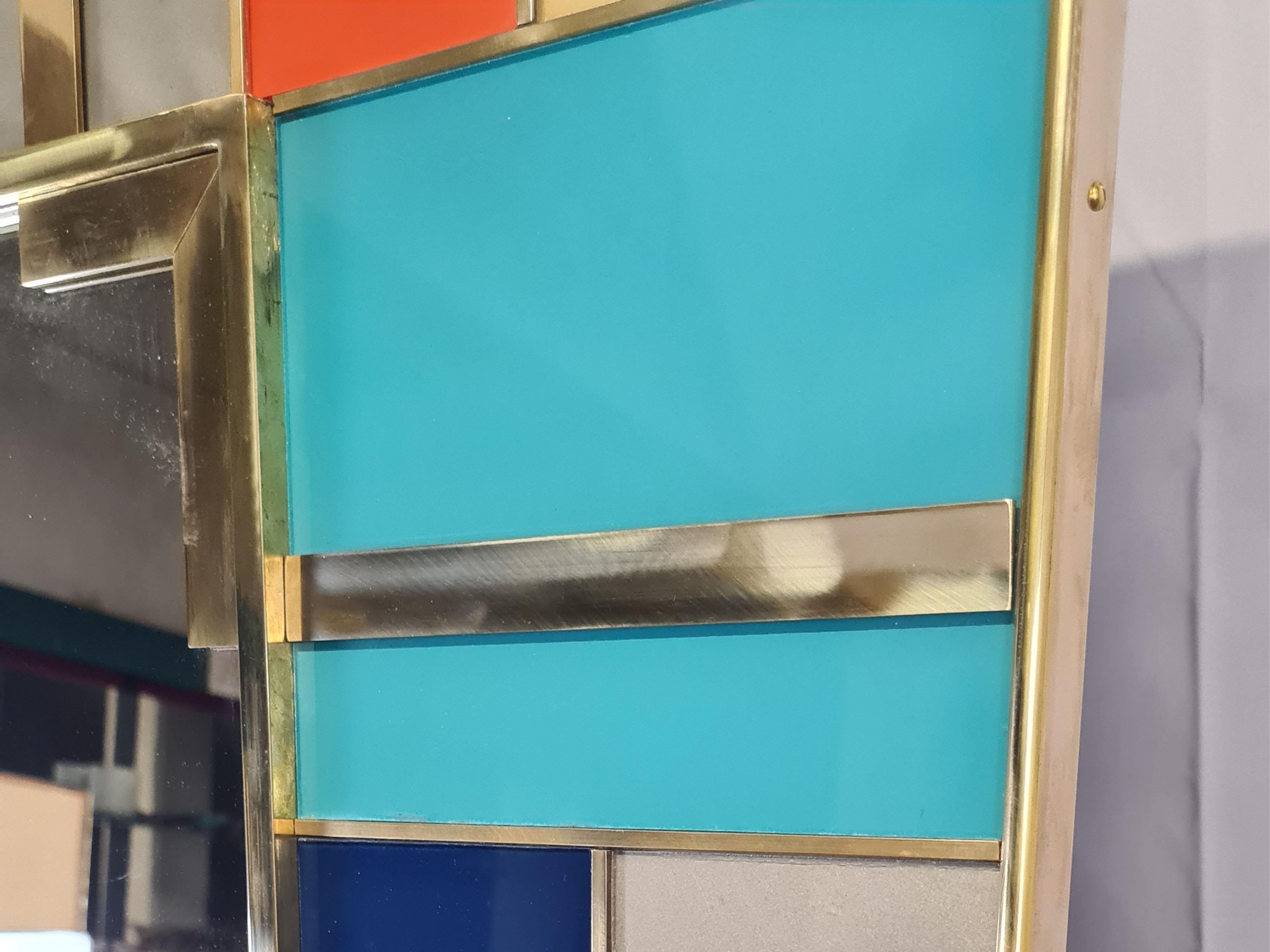 Elevate your space with this Multicolor Murano mirror, made with precision in Italy. 

This mirror features a series of hand-painted and hand-carved Murano glass panels, each separated by hand-welded brass inserts. 

The modern style of the mirrors,