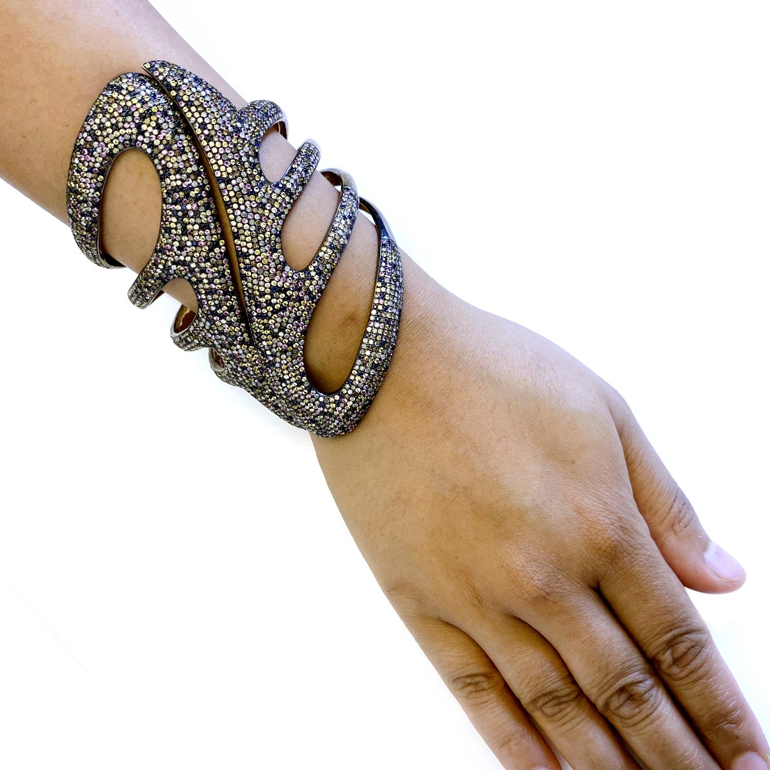 This splendid Multicolor Sapphire and Diamond Cuff is 3.85 inch long on wrist  and opens up on top to wear. 

18kt:0.6gms
Diamond:11.16cts
Slv:80.59gms
Sapphire:15.10cts