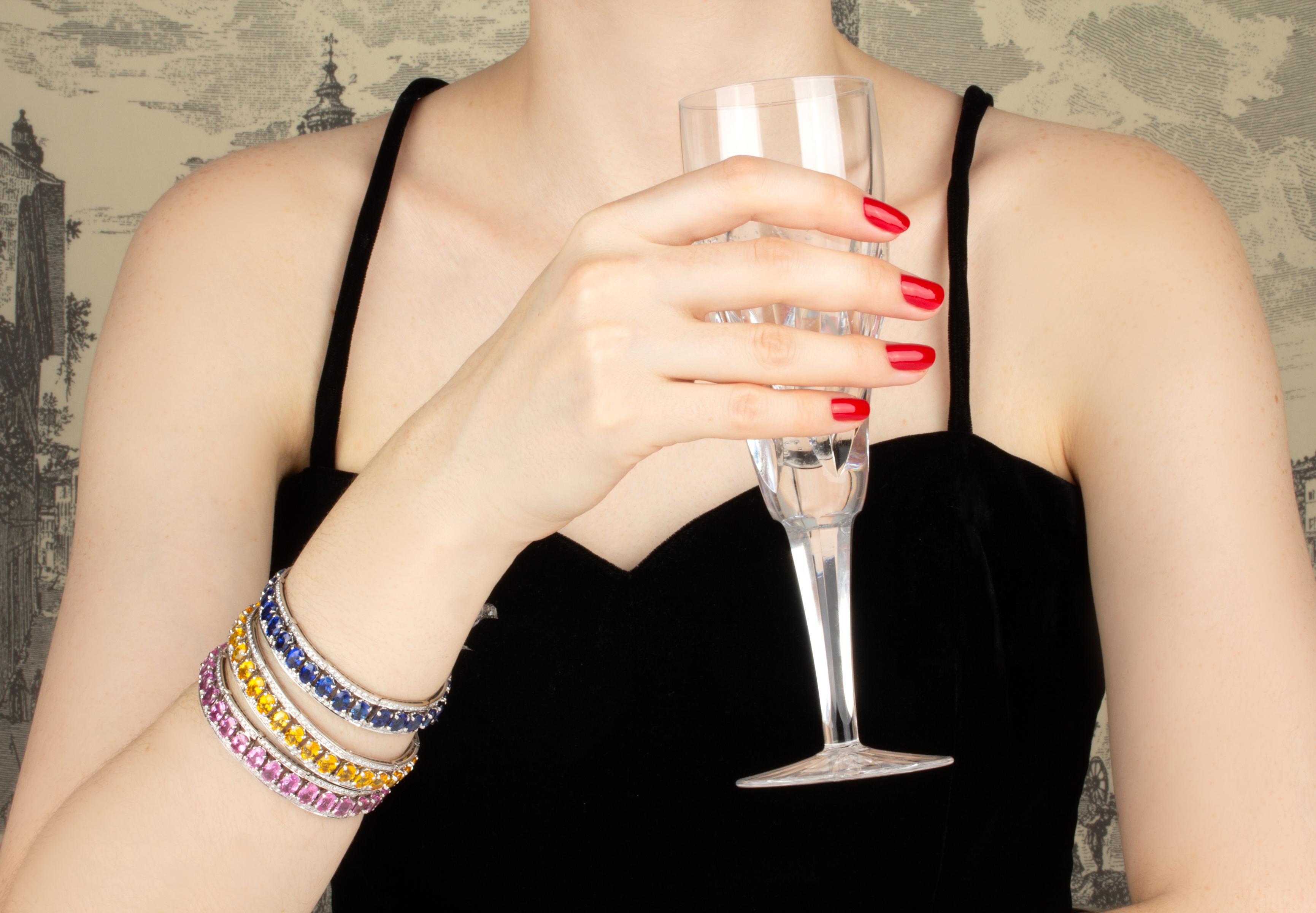 The multicolor sapphire bracelet set with diamonds features 3 bracelets each with 30 calibrated oval cut sapphires of brilliant hues and crystalline texture for a total of approximately 105 carats. Each design is complete with top quality diamonds