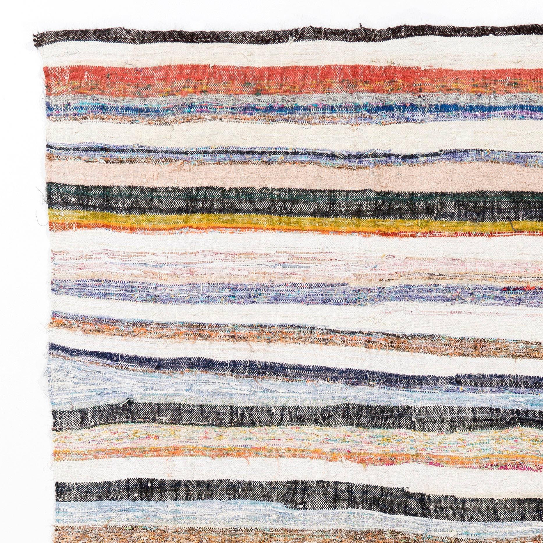 An authentic flat-weave (Kilim) from Eastern Turkey, handwoven by Nomads to be used as floor coverings in their tents and winter homes. This kilim features a simple design of stripes in refreshing colors of burnt orange, cream, pink, black, blue,