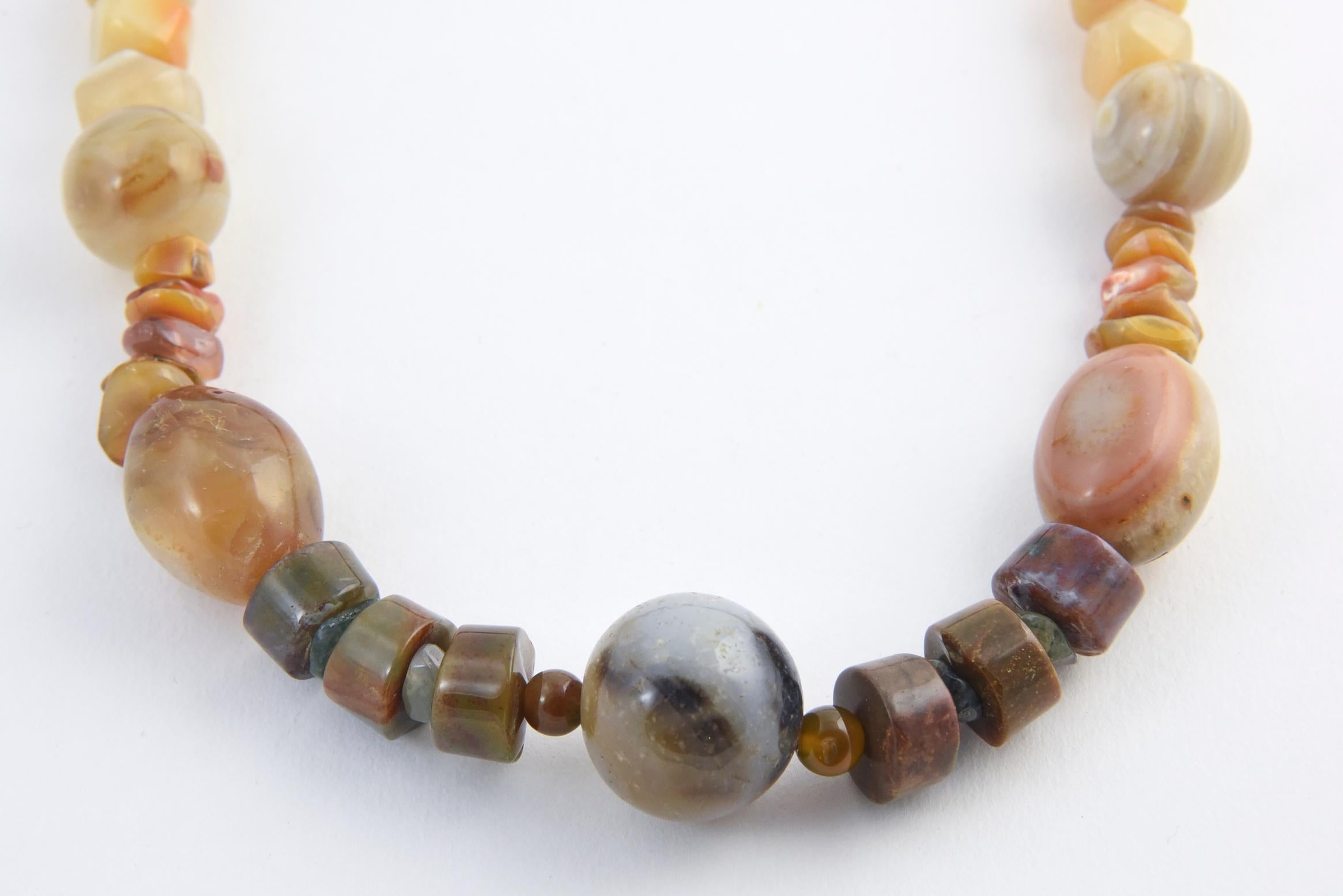 Multicolored agate necklace with rough amethyst accents and brass-and-Bakelite hook clasp. Agate pieces range in shape from round to tumbled. Largest bead, 25mm. Clasp has a chip and traces of glue.
