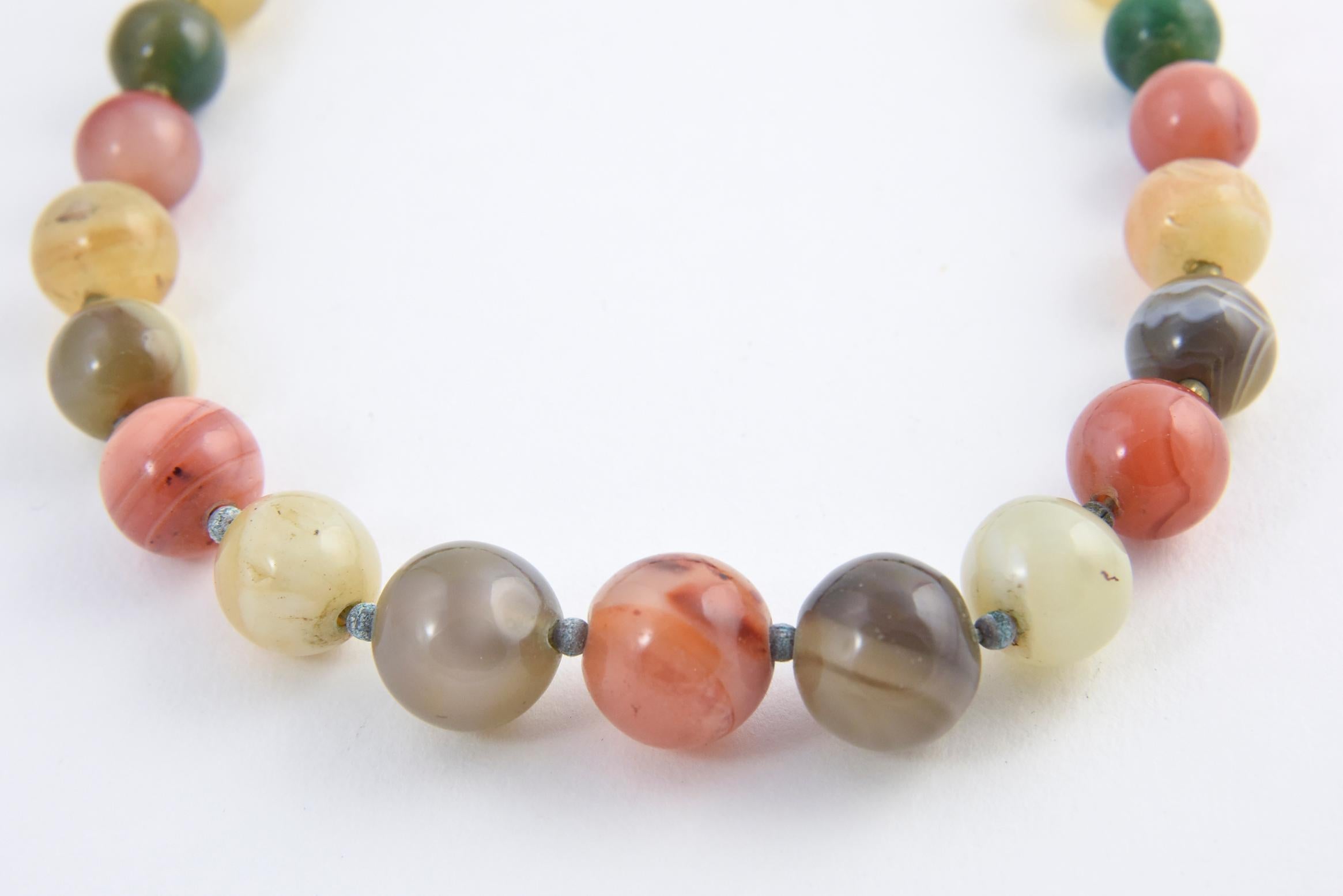 Multicolored agate bead necklace with four aventurine quartz accent beads, brass bead spacers, and clasp. Beads range from 10.5mm to 17.30mm. Tarnish on brass beads. No maker's mark.

