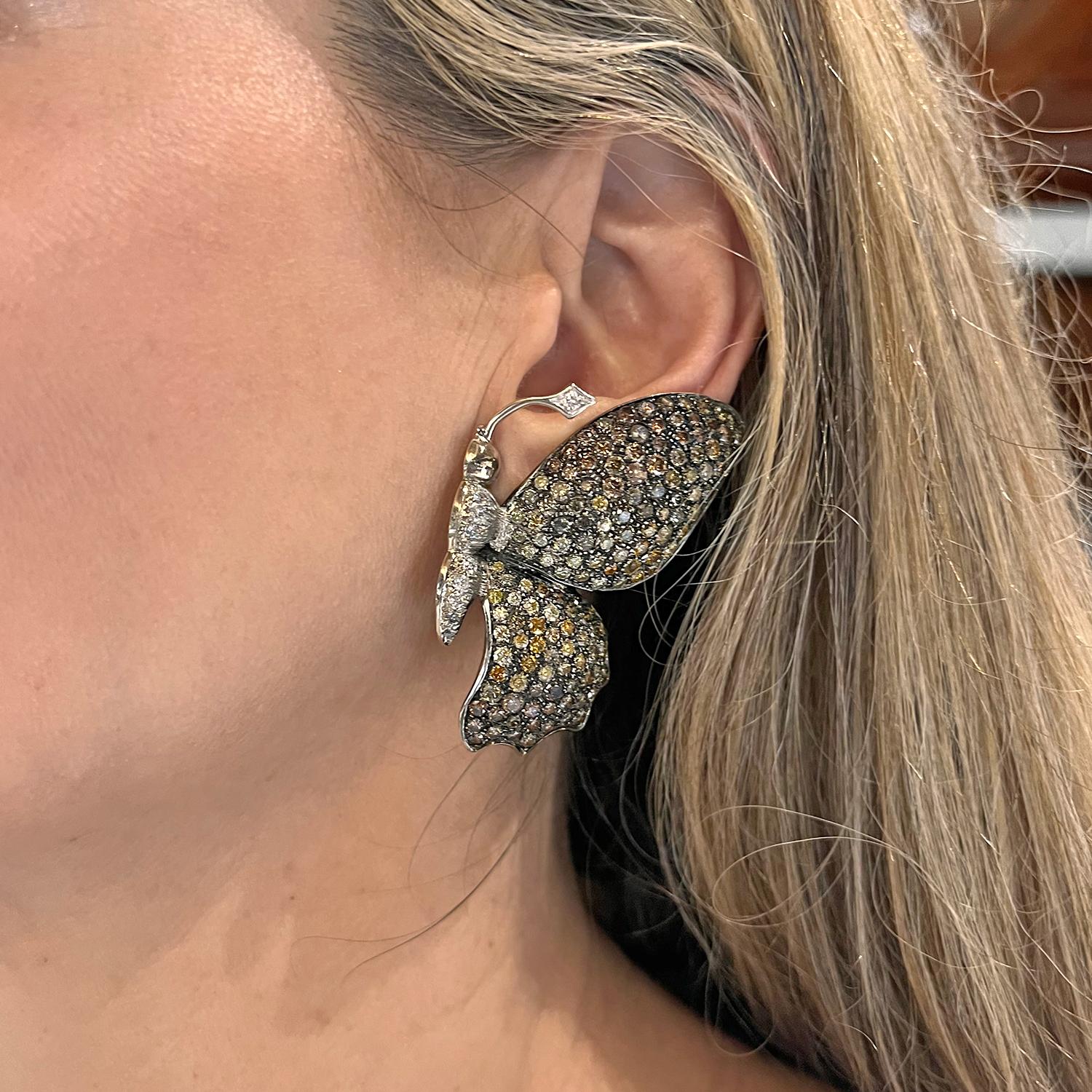 Butterfly earrings in black oxidized and polished 18k white gold, the body and antennae set with round brilliant-cut white diamonds and wings set with various-sized round brilliant-cut yellow, orange, olive, brown and champagne-colored diamonds. 