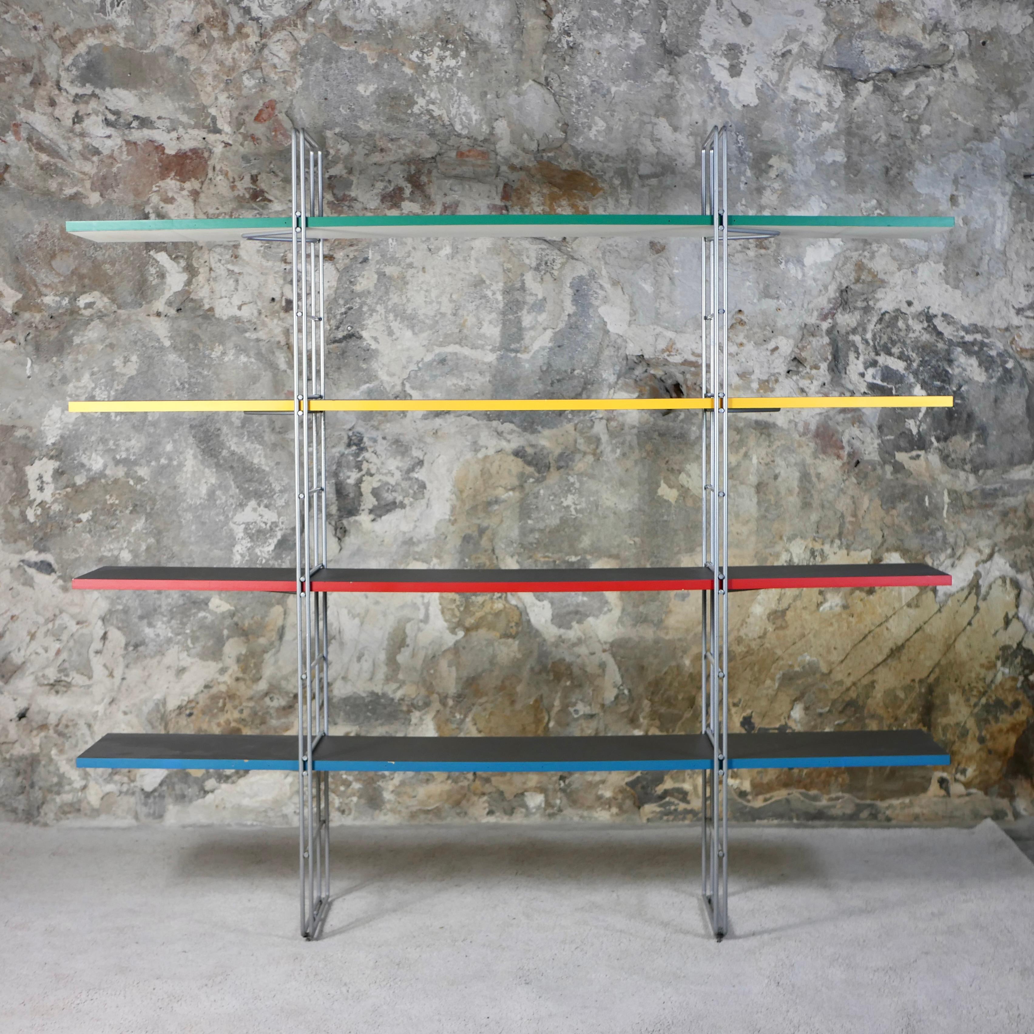 “Guide” Shelving Unit in its multicolored version, designed by Niels Gammelgaard for IKEA in 1985. 
A post-modern design classic known for its elegance, sturdiness and practicality. 
Minimalist structure in grey powder-coated steel, four shelves