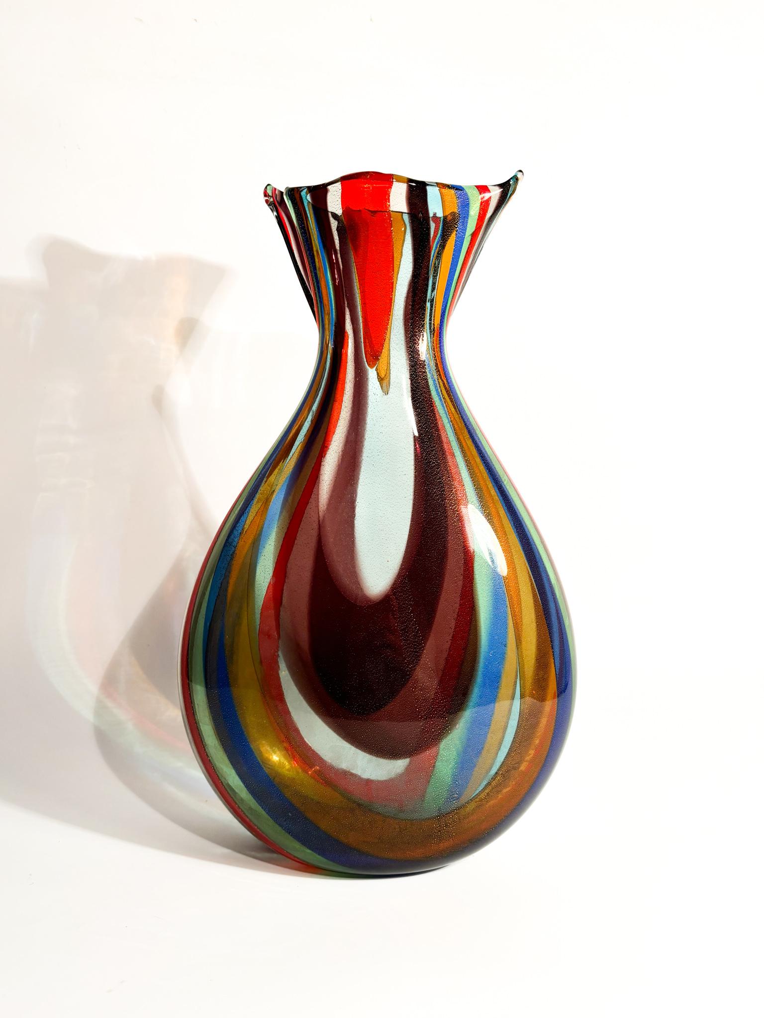 Mehrfarbige Vase aus Murano-Glas mit gestreiftem Dekor und Aventurineinschlüssen, hergestellt von La murrina in den 1980er Jahren

Ø cm 20 Ø cm 12 h cm 35

La murrina ist ein bekanntes Unternehmen aus Murano, das sich auf die Herstellung von