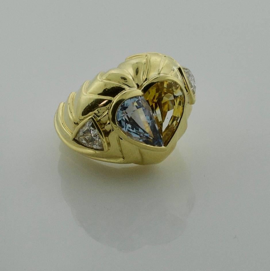 Multi-Colored Sapphire and Diamond Ring in 18k Yellow Gold
One Half-Moon Cut Blue Sapphire weighing 2.50 carats approximately
One Half-Moon Cut Golden Sapphire weighing 2.50 carats approximately
Two  Trillion  Cut Diamonds weighing 1.00 carats