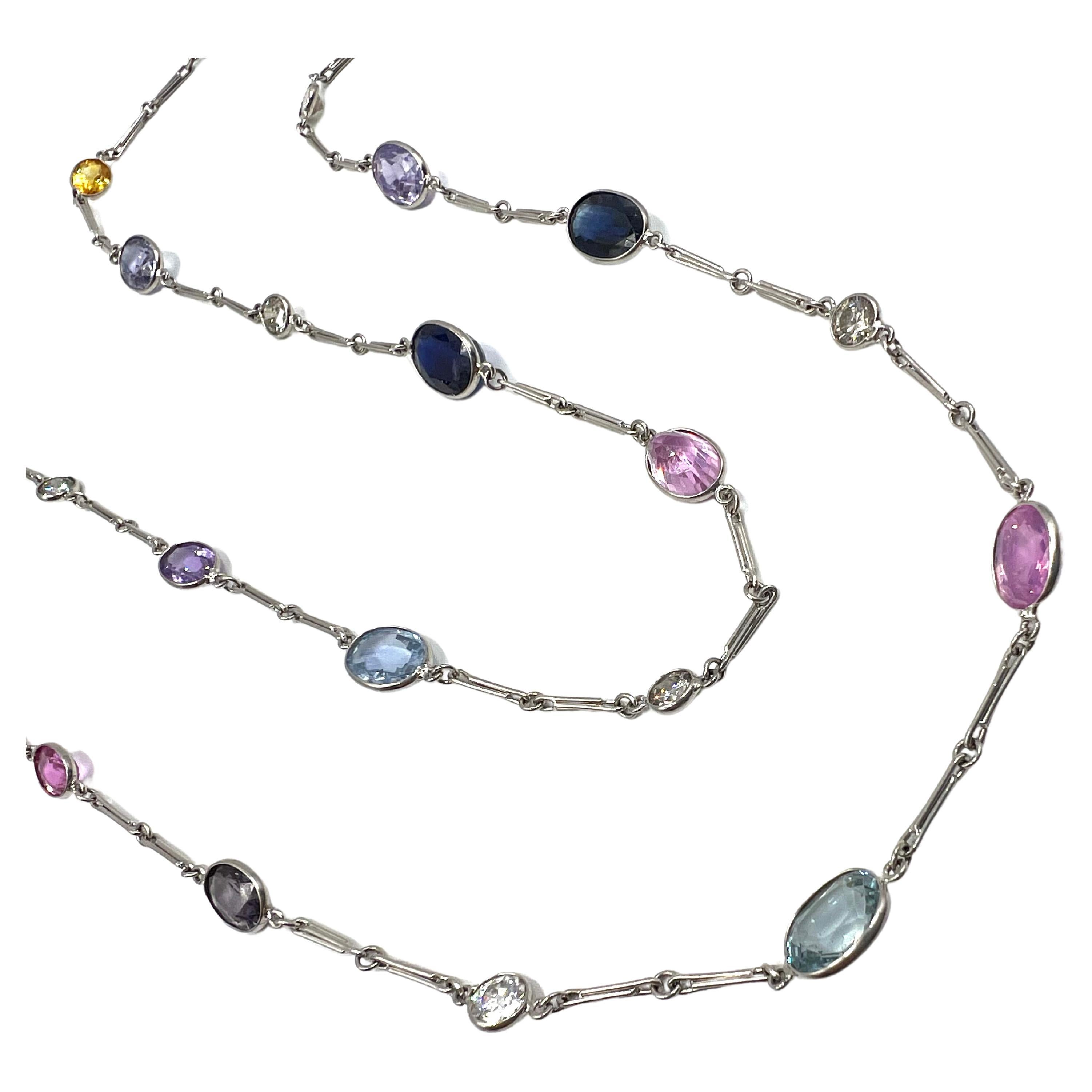Platinum neck chain in a gemstone by the yard design, featuring alternating multicolored gemstones and diamonds. Bezel set with 24 oval mixed cut sapphires totaling approx. 41.88ct. (4 yellow, 8 blue, 6 pink and 6 violet/purple). Eleven round