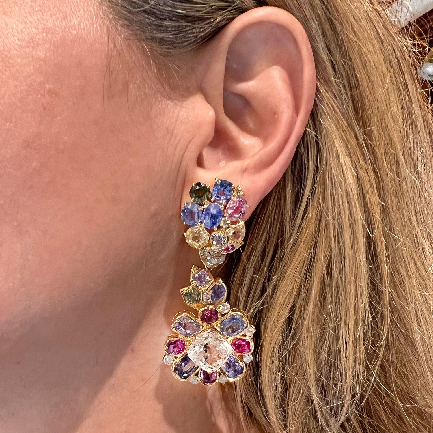 Beautiful multicolored sapphire drop earrings, featuring various-shaped faceted natural and unheated sapphires (pink, purple, blue, yellow, green and white hues), accented by round brilliant-cut diamonds. Handmade in 18k yellow gold. Drops are