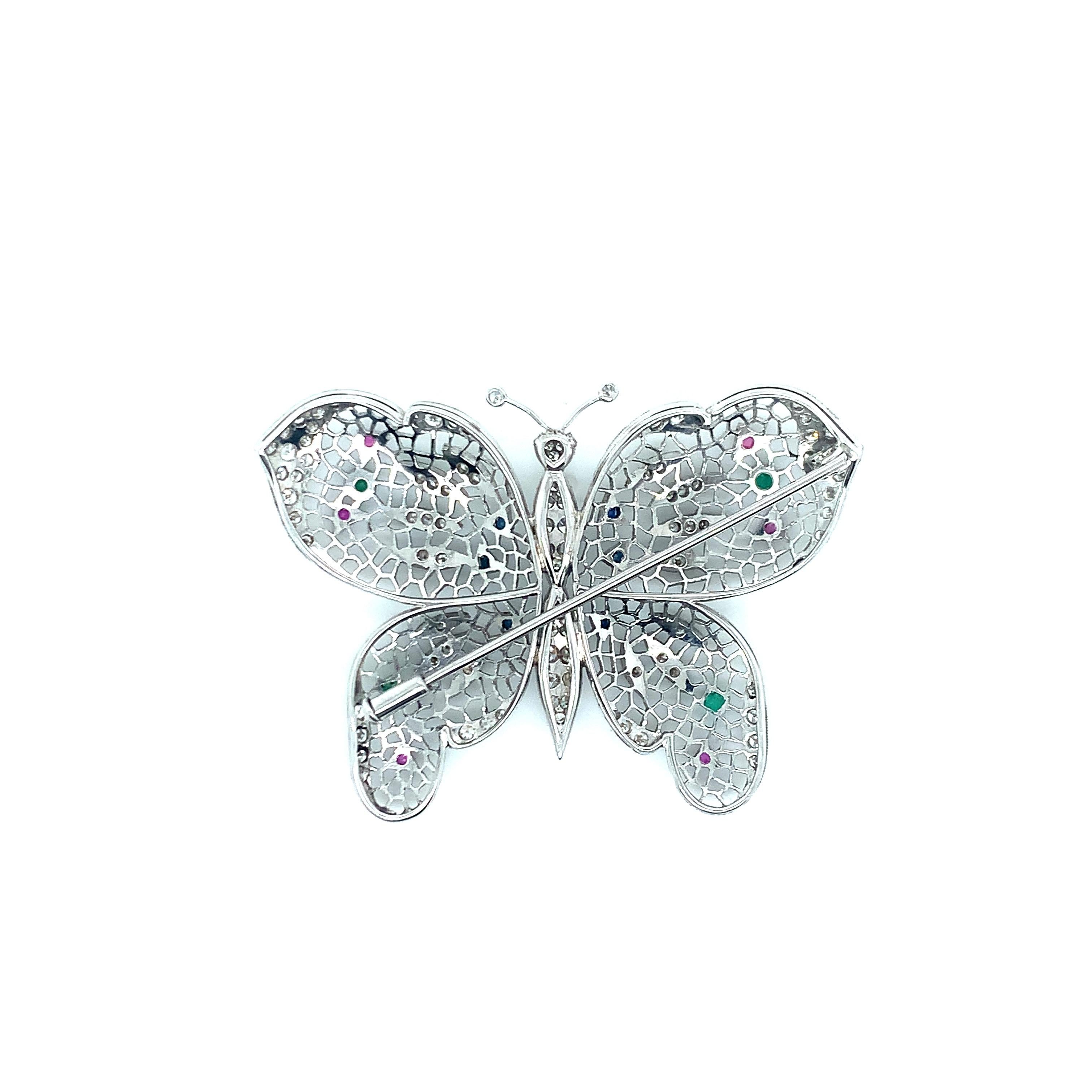 Set in 18 karat white gold, this butterfly features 1.5 carat diamonds as well as several other stones sprinkled throughout, including emeralds, sapphires, and rubies. The wings have a honeycomb pattern. Total weight: 10.0 grams. Width: 2.13 inches.