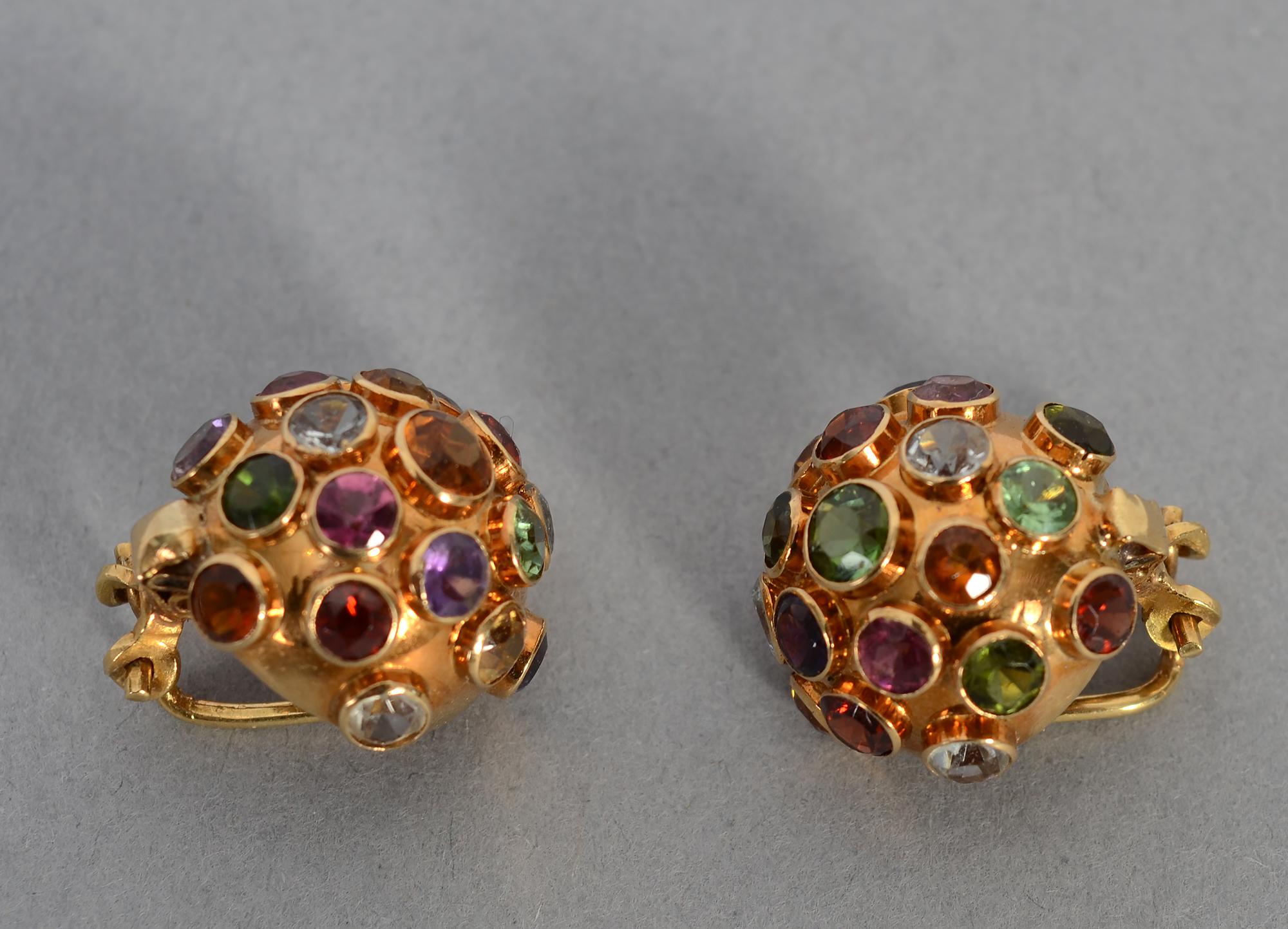 The domed, multigem Sputnik design is emblematic of the 1950's. These earrings are studded with faceted stones that include amethyst; peridot; citrine;  blue topaz and various shades of tourmaline. The stones are of varying sizes.
Clip backs can be