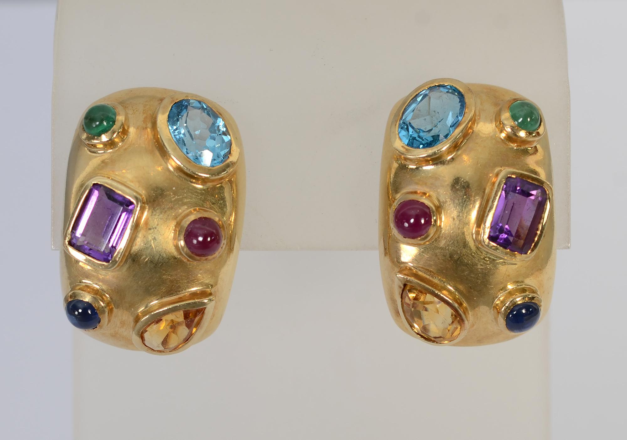 Festive and colorful 14 karat half hoop earrings with stones that include: amethyst; citrine; blue topaz and tourmaline. The stones are a variety of shapes and sizes. Backs are posts and clips. Signed CK.
The earrings are 3/4
