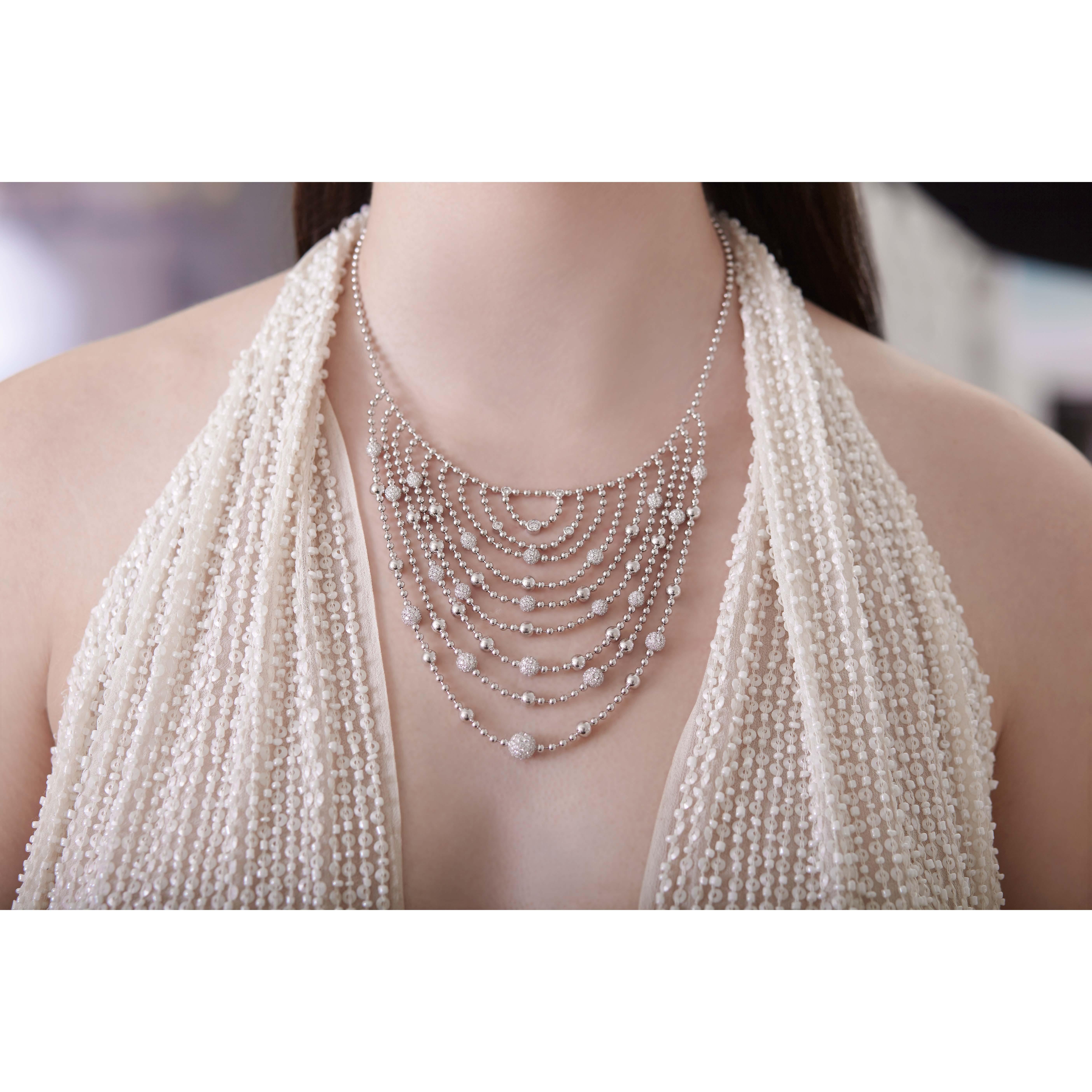 Silky 18K gold ball chain drapes dramatically, filling your neckline. Each slinky swag has stations of pave diamond spheres, bezel-set diamonds, and spheres of 18K gold in a pleasing rhythm.  Wear it inside a collar for the perfect subtle layers or
