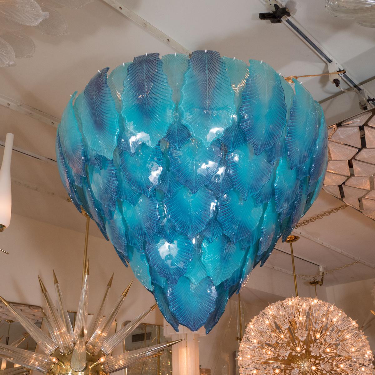 Multilayered chandelier featuring deep blue leaf form glass elements.