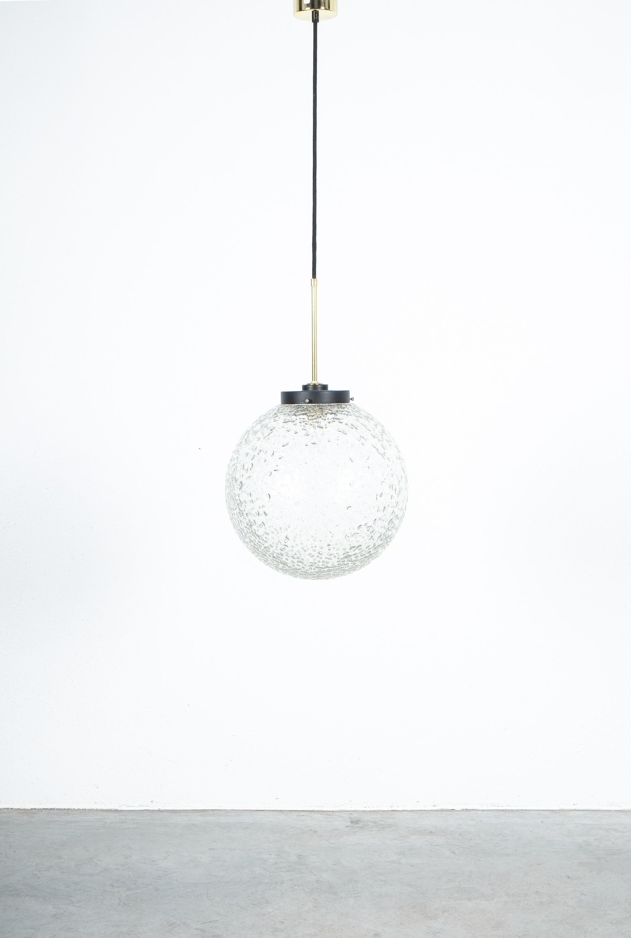 1 out 10 glass ball lights with thick clear ice glass and brass hardware by BAG Turgi, Switzerland, 1960.

Priced and sold individually

Pendant light in refurbished condition, labelled with new canopy. The globe fixtures are in very good