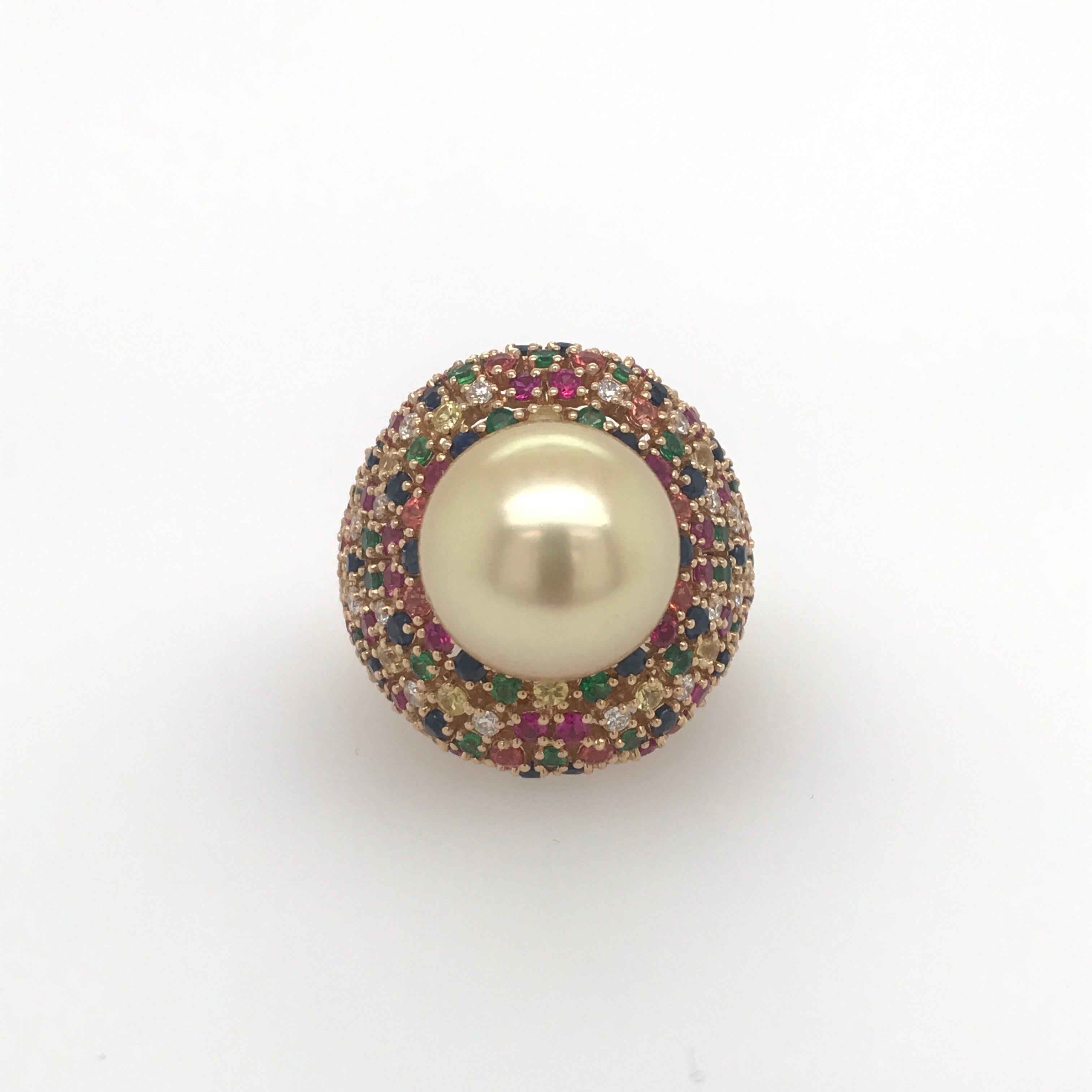 18K Yellow Gold dome ring featuring one golden pearl measuring 13-14 mm flanked with numerous multi color sapphires weighing 3.80 carats and diamonds weighing 0.46 carats. 