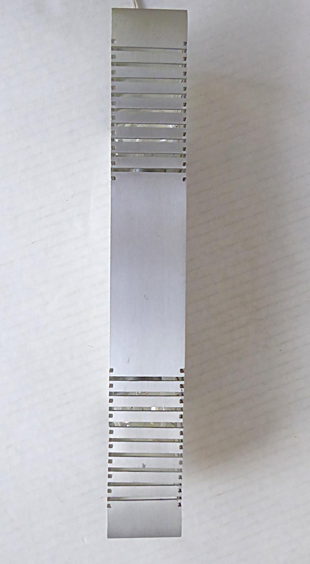 1960s European Space Age Mid Century Modern Sconce (3 available) in brushed aluminum. Square tubular form with cut-outs in front and sides with round cutouts, back no cutouts. White enamel inside walls where bulb goes. The sconces are hardwired and