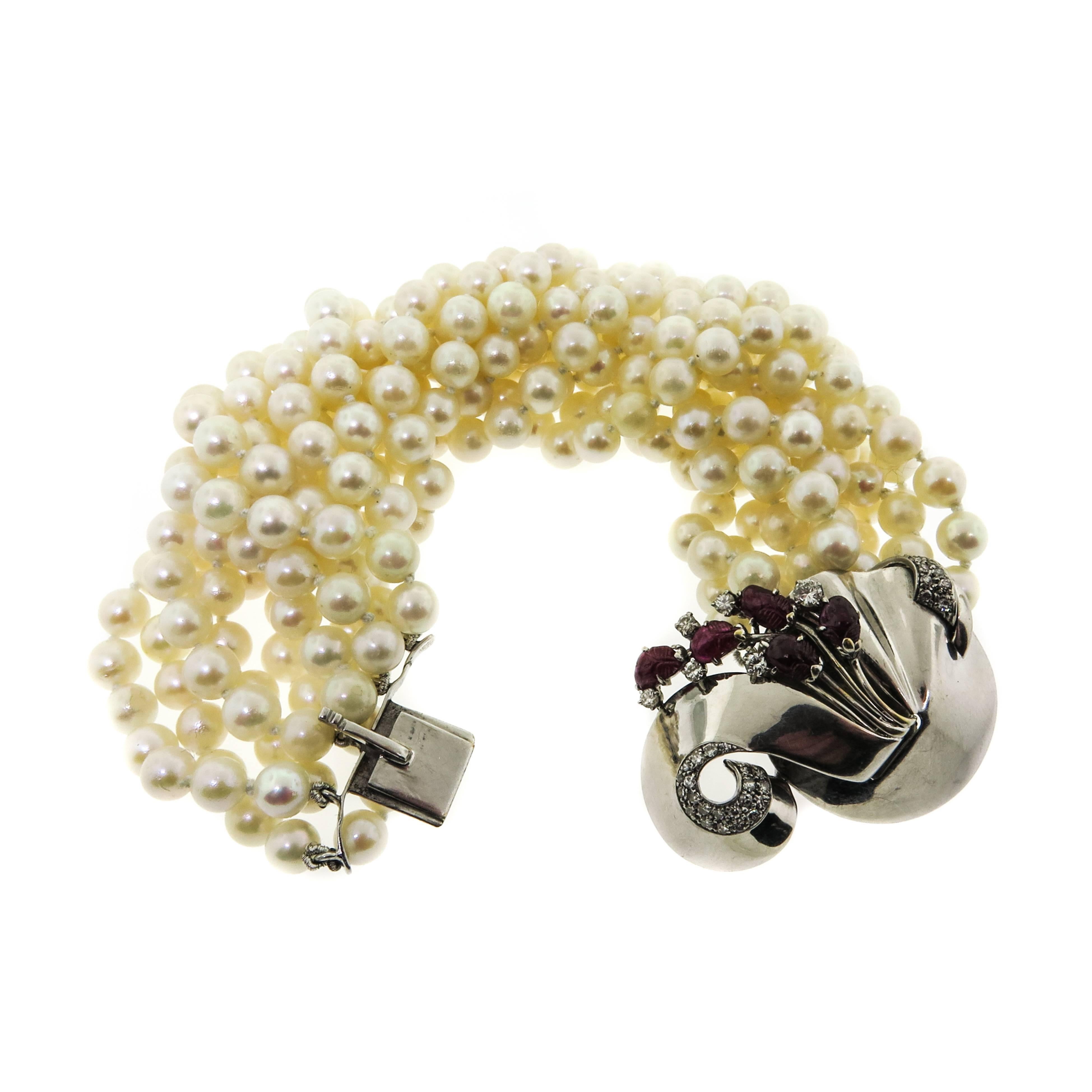 Every lady needs a fabulous pearl bracelet in her jewelry collection!. The torsade design of this bracelet is ornamented with a combination of pearls, diamonds and rubies.Centering an elegant 18kt white gold clasp featuring 5 carved cabochon rubies