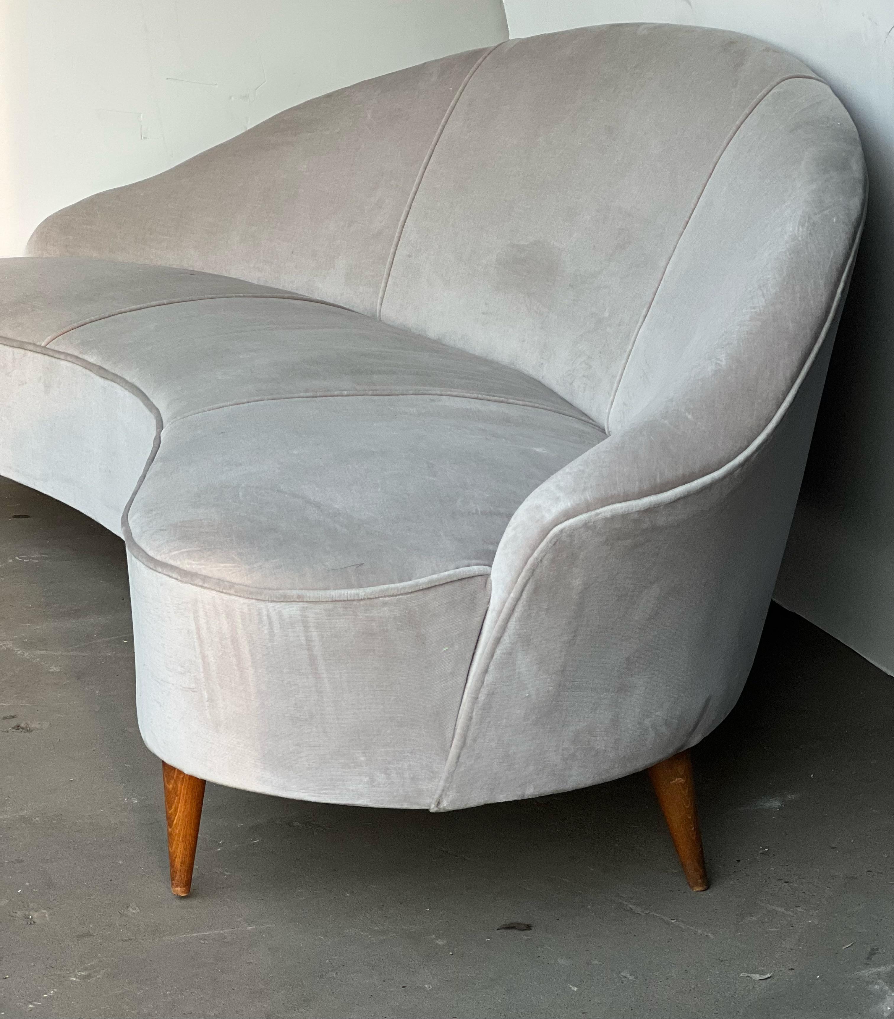 Beautiful Italian curved sofa with performance grade velvet that sits upon wooden legs in the style of Munari. This is a fabulous piece that can be reupholstered and used in any setting from traditional to modern. The upholstery shows imperfections