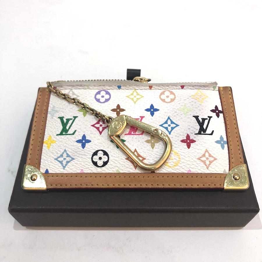 Collectible piece designed by Murakami for Louis Vuitton at the beginning of the century. Crafted with multicolored monogram on white canvas, with natural color leather edges. The hardware is in gold tone metal. This key holder in in good vintage