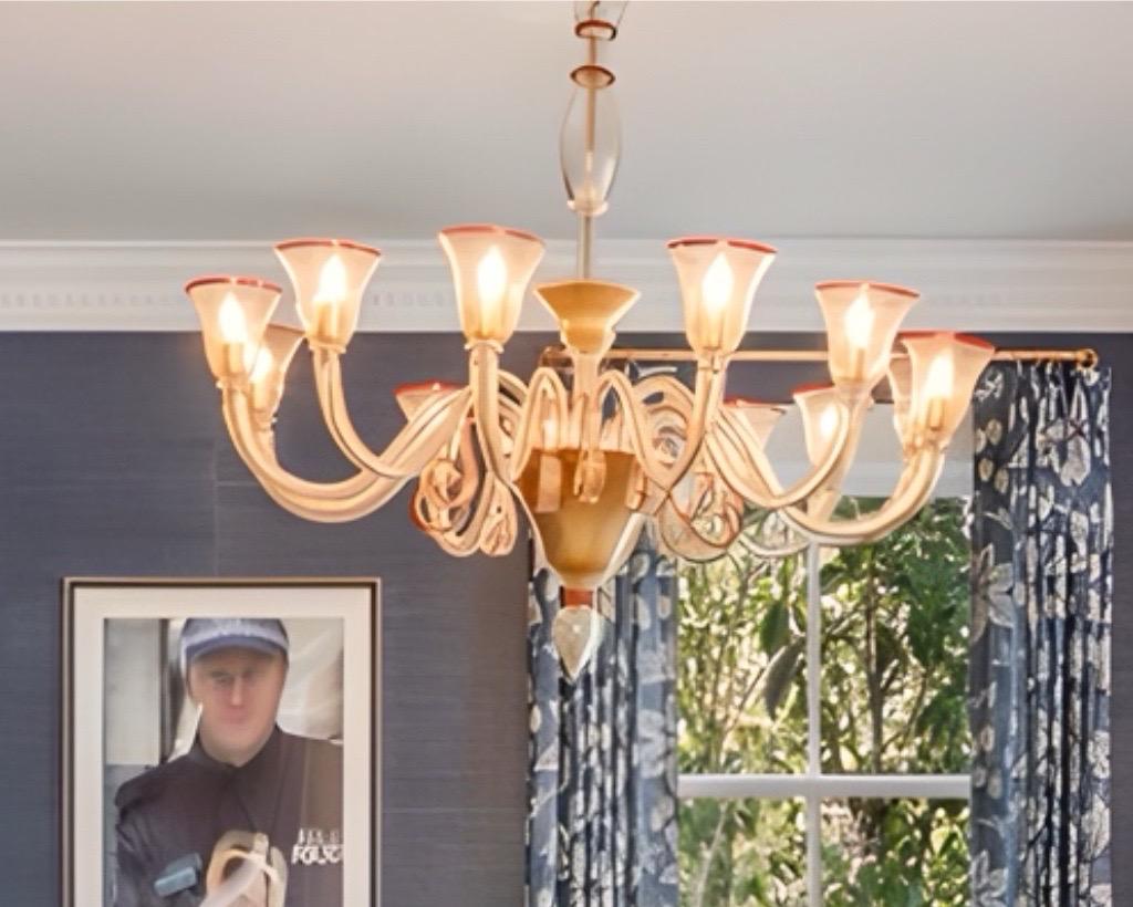Un lampadario a 12 bracci in vetro di Murano assolutamente straordinario.  Il vetro delle braccia è un  chiaro  con macchie d'oro e splendidi dettagli rossi.  Il corpo del lampadario è d'oro.   I nastri di vetro arricciato  Can può essere