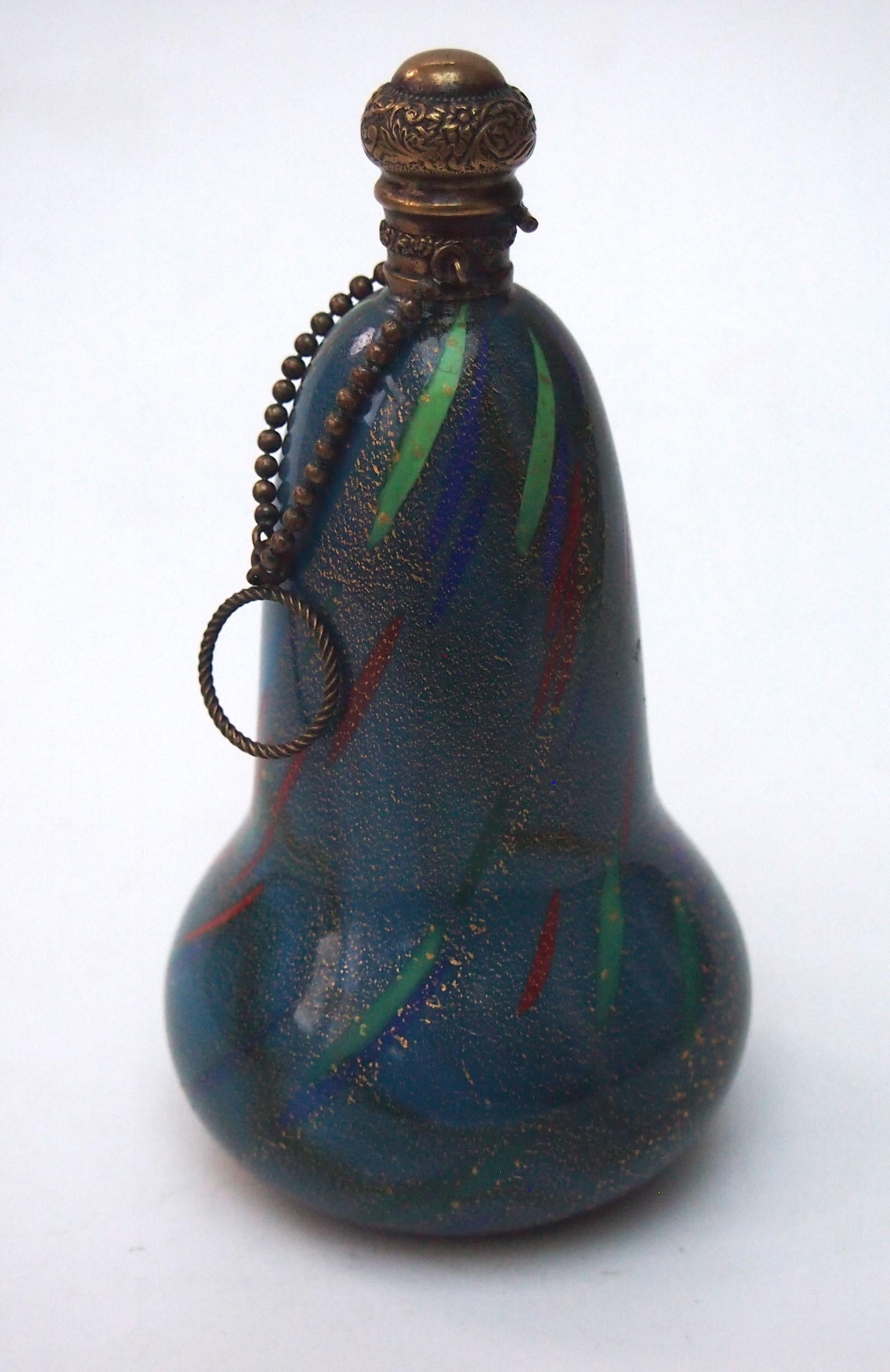 A vibrant Venetian medium-large glass scent bottle (just under 6 inches tall) with original glass stopper and metal hinged cap and chatelaine chain attachment. The glass sent bottle is from Murano and was made c1890. The finely moulded metal stopper