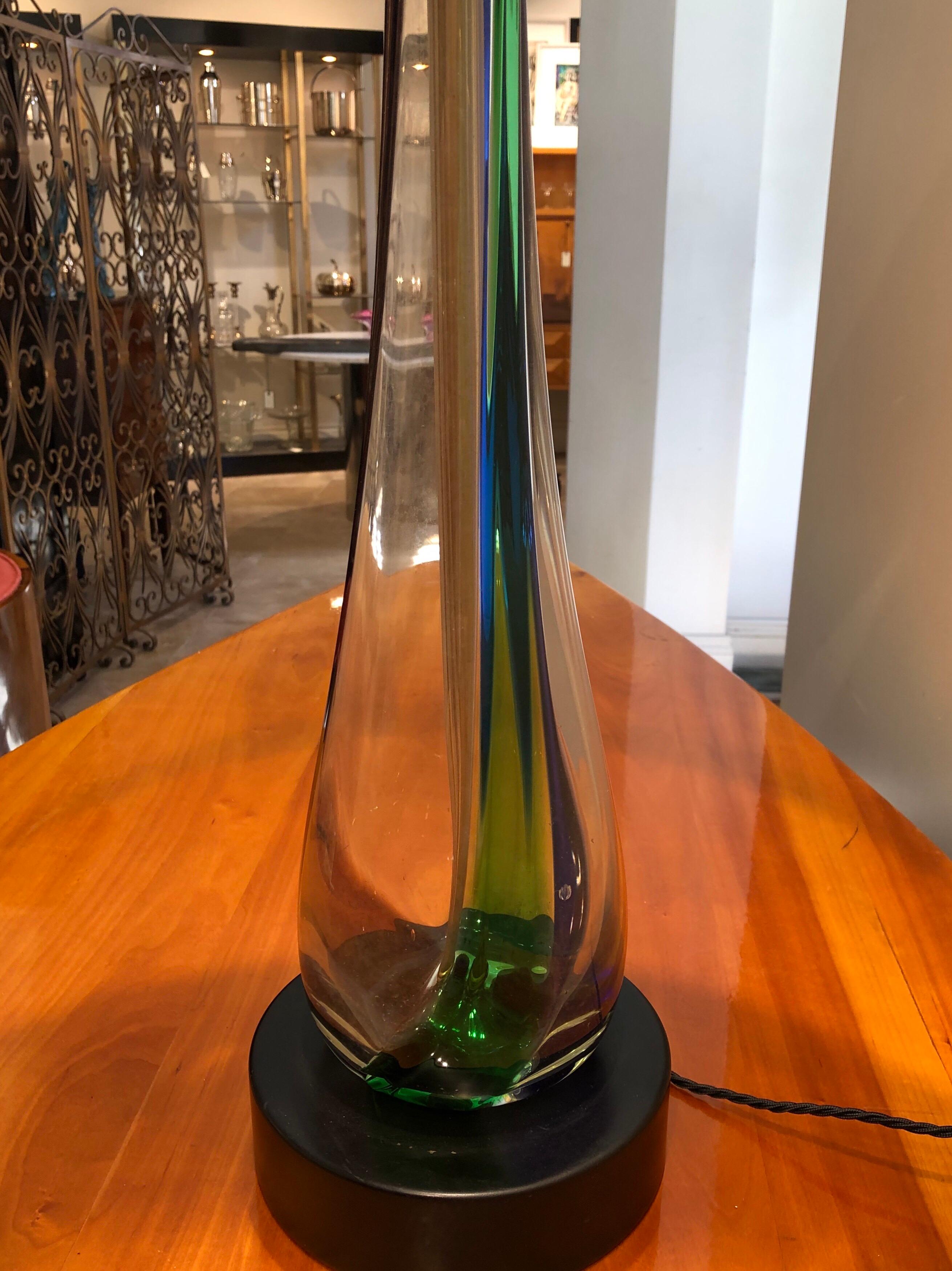 A tall multicolored hand blown glass table lamp made in Murano Venice in the 1960s with a black lampshade.The glass is clear with swirls of blue, green and purple running through it.
