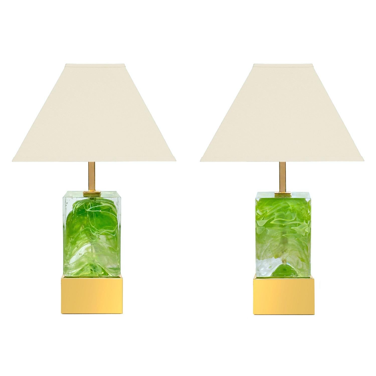 A modern take on a traditional method. This artisan pair of clear Murano glass block lamps contain a frenetic abstract swirl of vibrant green sommerso glass set against a polished brass body.  Also available in swirls of red , blue, yellow and