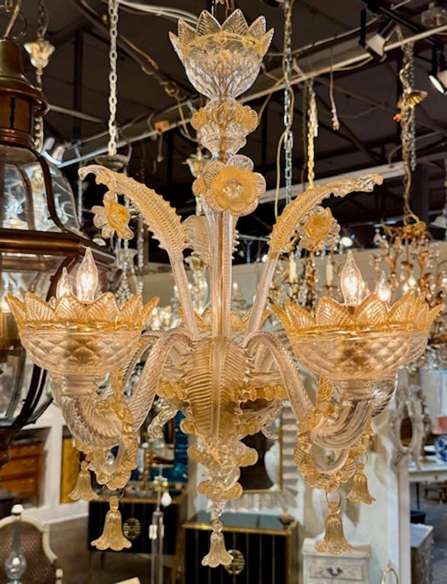 Splendido lampadario a 5 luci in vetro ambrato e trasparente di Murano. Ognuno di questi lampadari è fatto a mano a Murano, in Italia, e riflette secoli di tradizione vetraria. Ognuno di questi lampadari riflette secoli di tradizione della