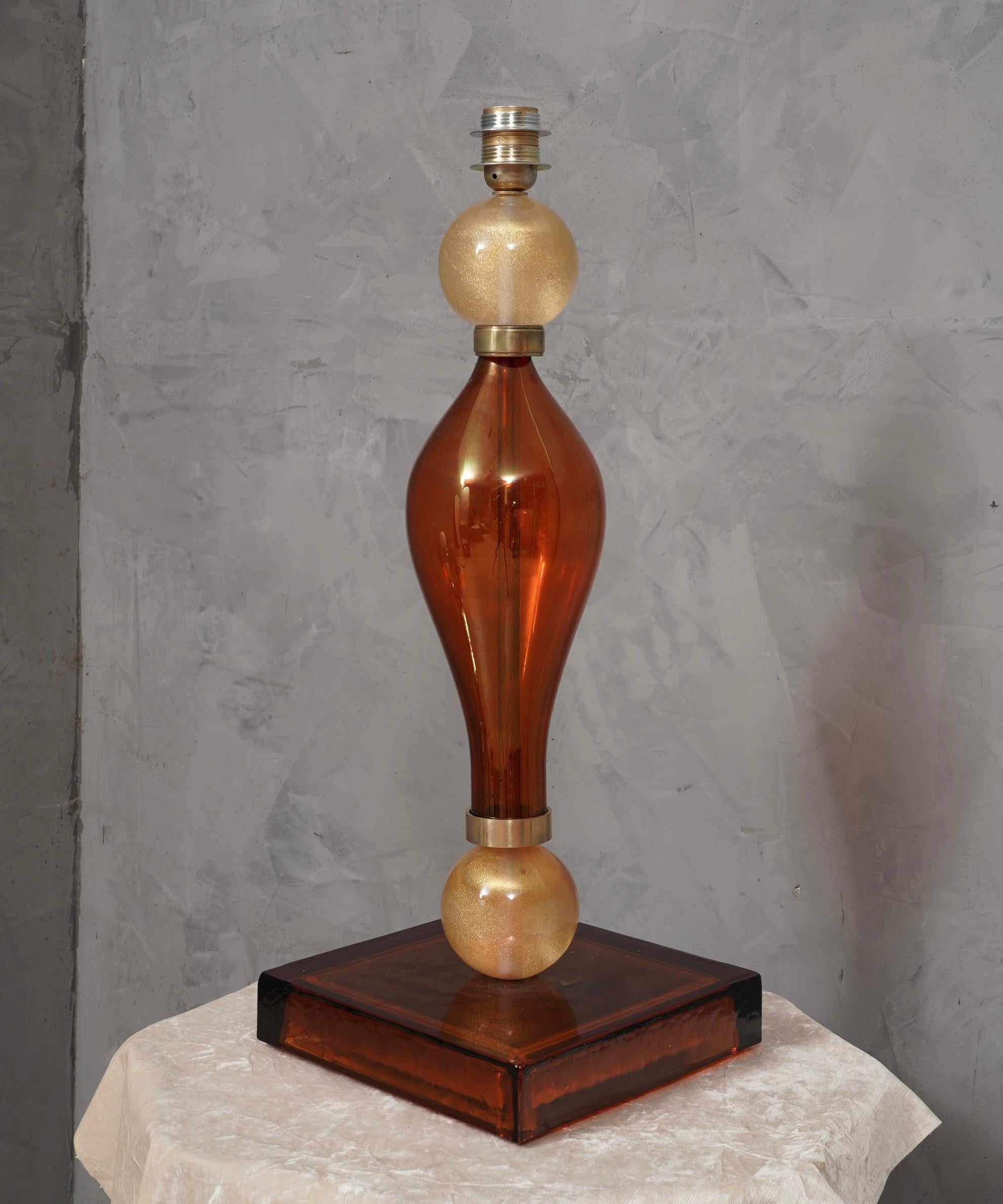 Incroyable beauté pour une lampe de table en verre ambré de Murano du milieu du siècle, élégante et d'une couleur très intense.

La lampe de table est entièrement réalisée en verre soufflé de Murano, de couleur ambre et or. Elle est composée d'un