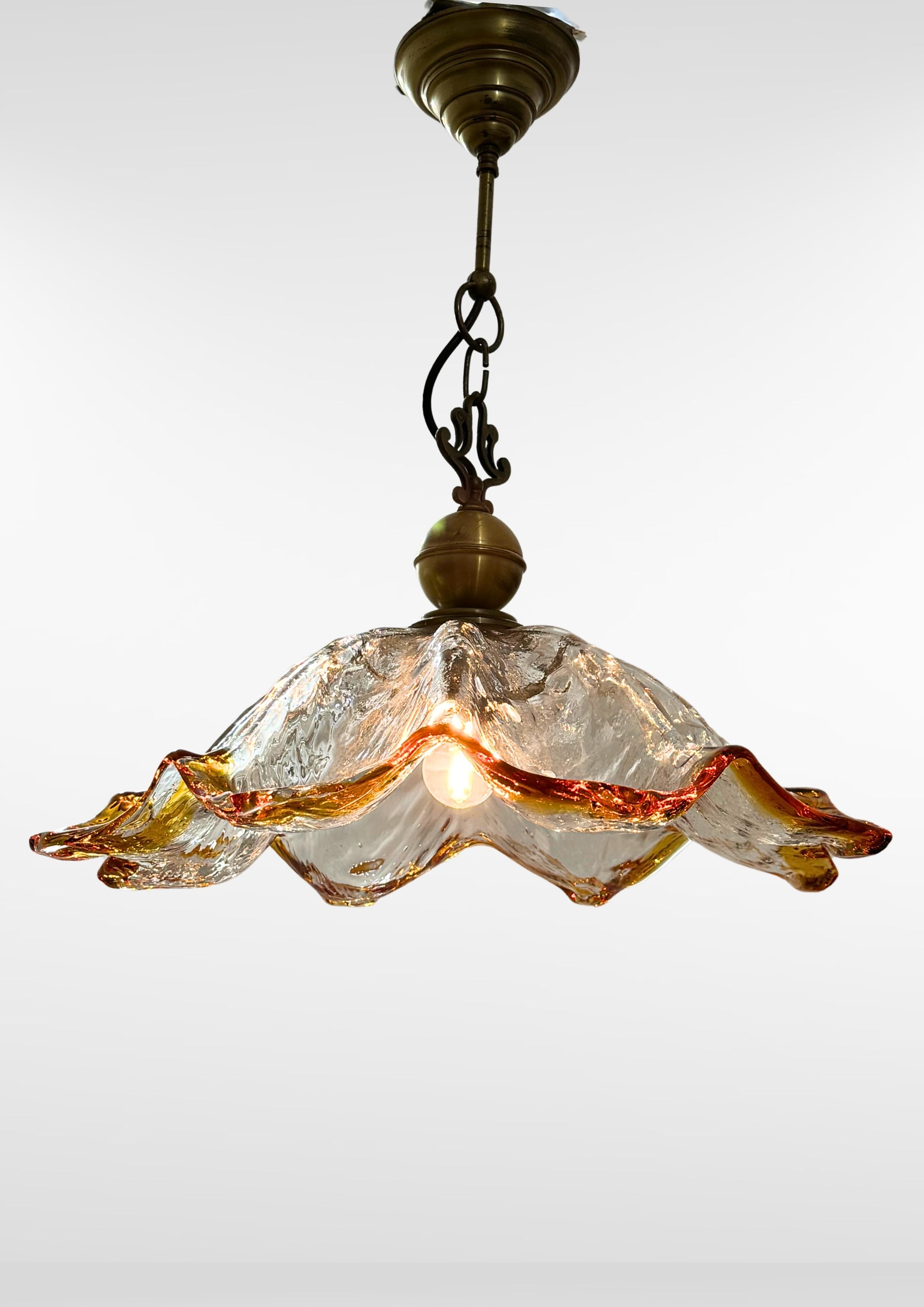 Deliziosa lampada a sospensione in vetro italiana della metà del secolo scorso, realizzata da Mazzega negli anni '60 circa.
Paralume a forma di girasole in vetro soffiato di Murano di grandi dimensioni.
Con bordo arancione ambrato e superficie