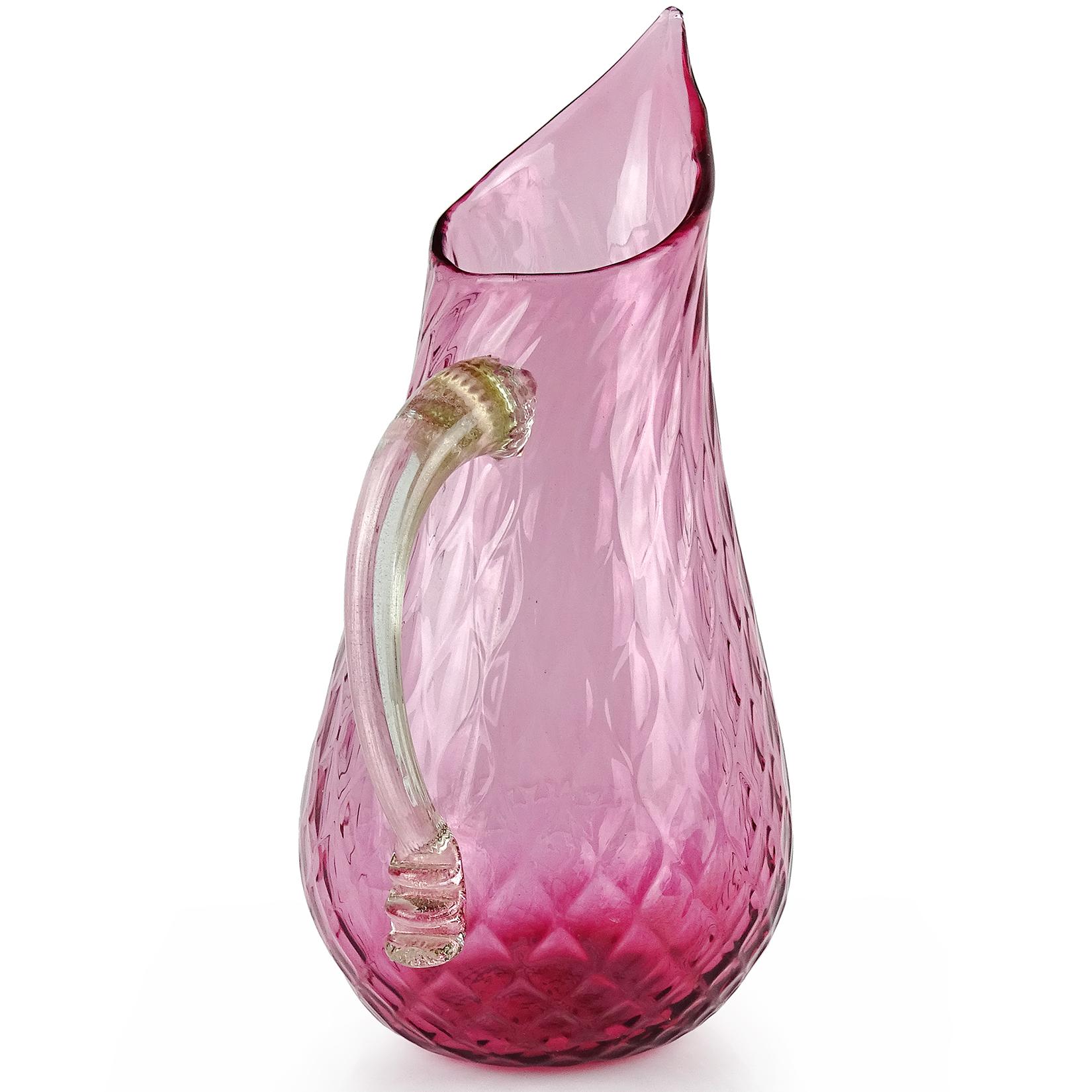 Beautiful large vintage Murano hand blown amethyst pink and gold flecks Italian art glass pitcher / flower vase. It has a diamond quilted design throughout the body, with applied handle in clear and gold leaf. Can be used as a display piece on any