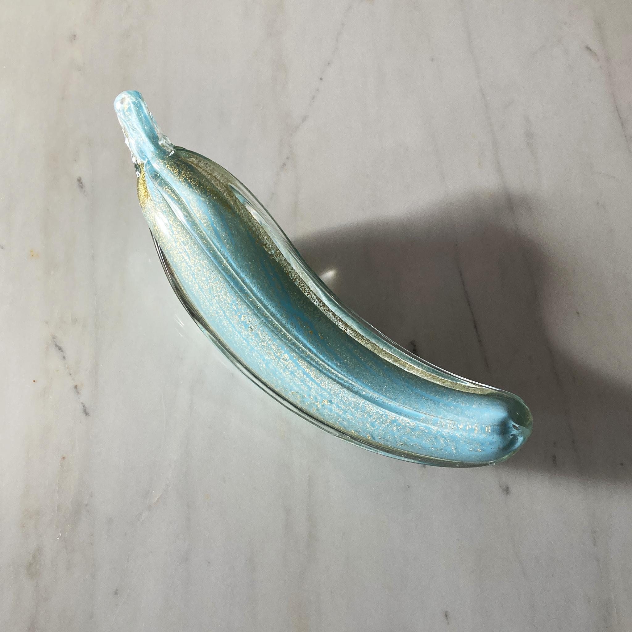 Stunning, unique Murano hand blown banana by Alfredo Barbini. Unique aqua glass is encased in gold, and clear glass. The glass glitters when the light hits this piece at different angles.

In very good vintage condition, a few small bubbles in