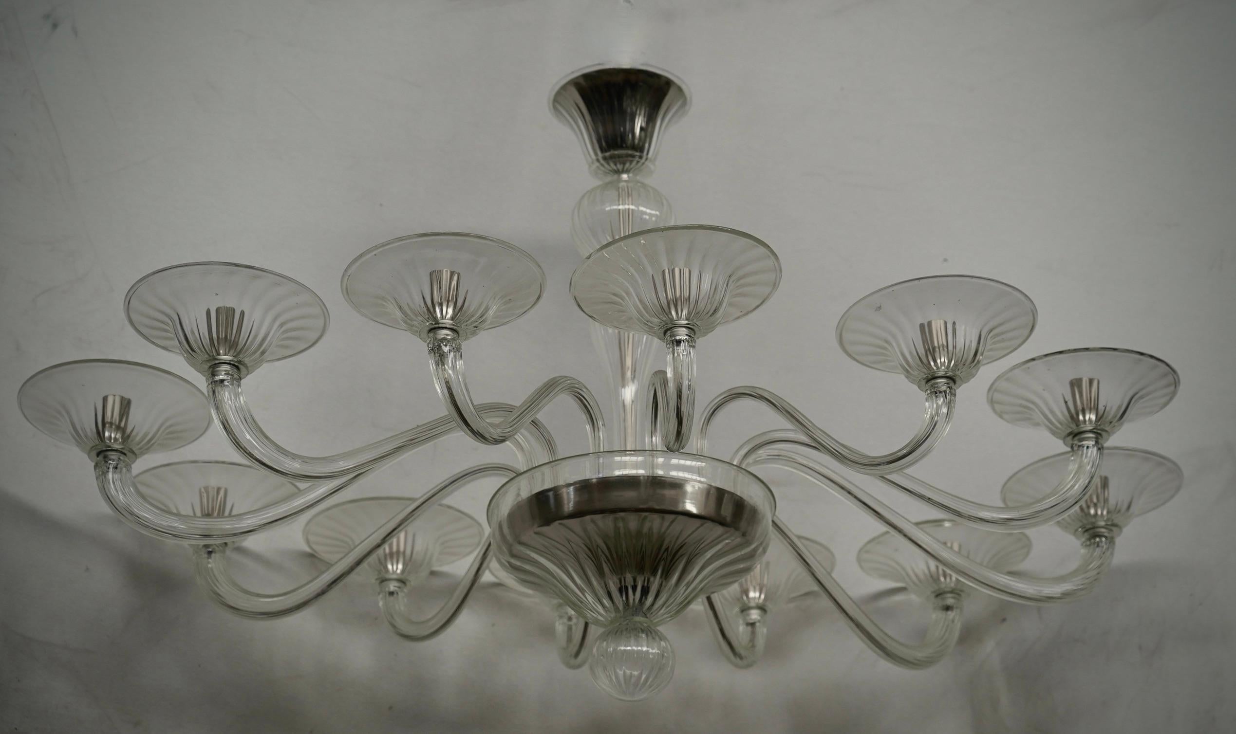 Magnifique lustre ovale en verre de Murano. Notez la forme classique en verre transparent de Murano, très belle et unique. Un lustre linéaire de Murano, simple mais très élégant.

Le lustre Murano est composé de douze bras incurvés de différentes